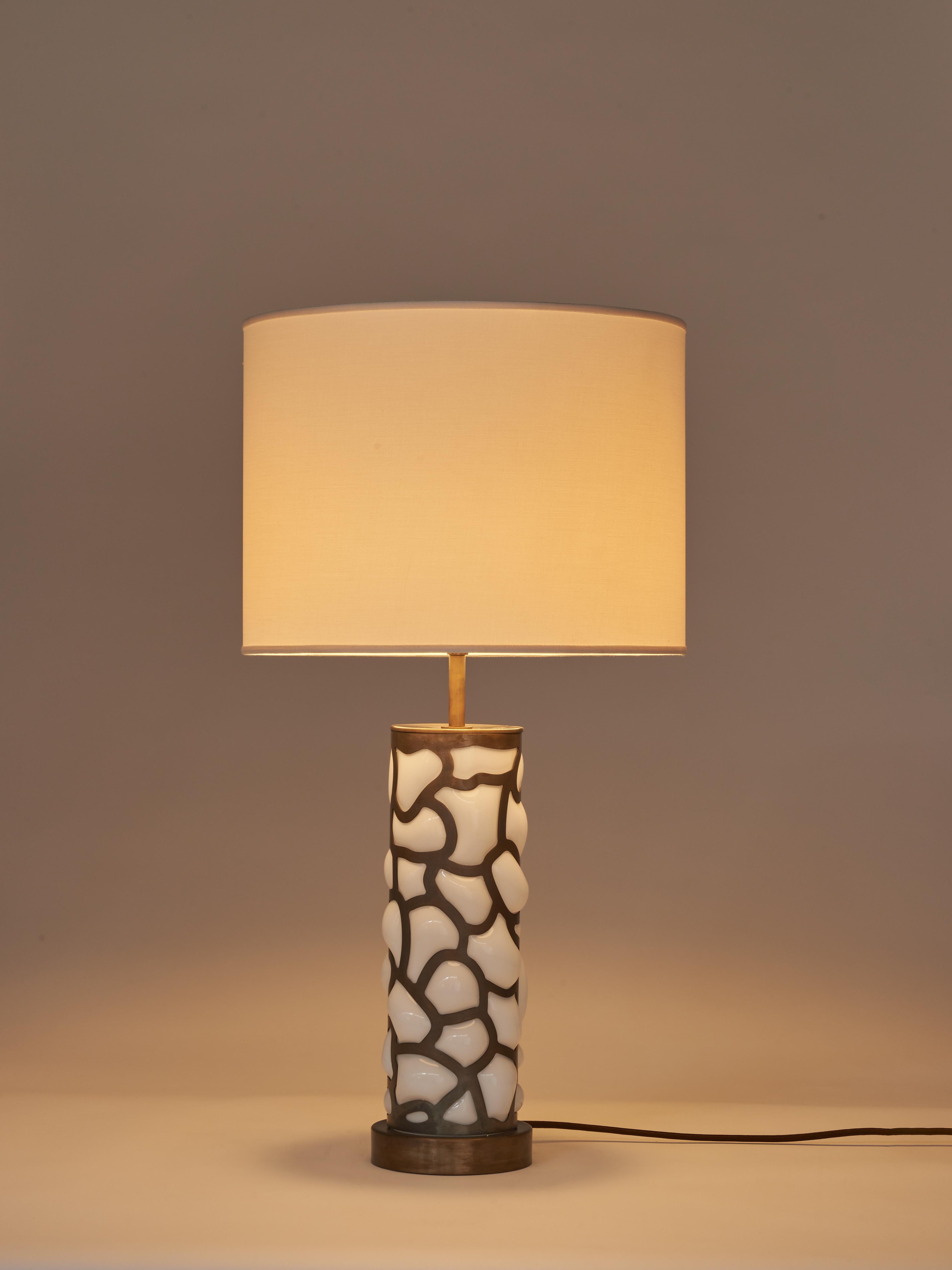 The table lamp from the Blown collection is the combination of advanced laser cutting technologies and the thousand-year-old practice of Murano glass blowing. Its brass cage structure with cloud pattern is complemented by Murano glass blown inside,