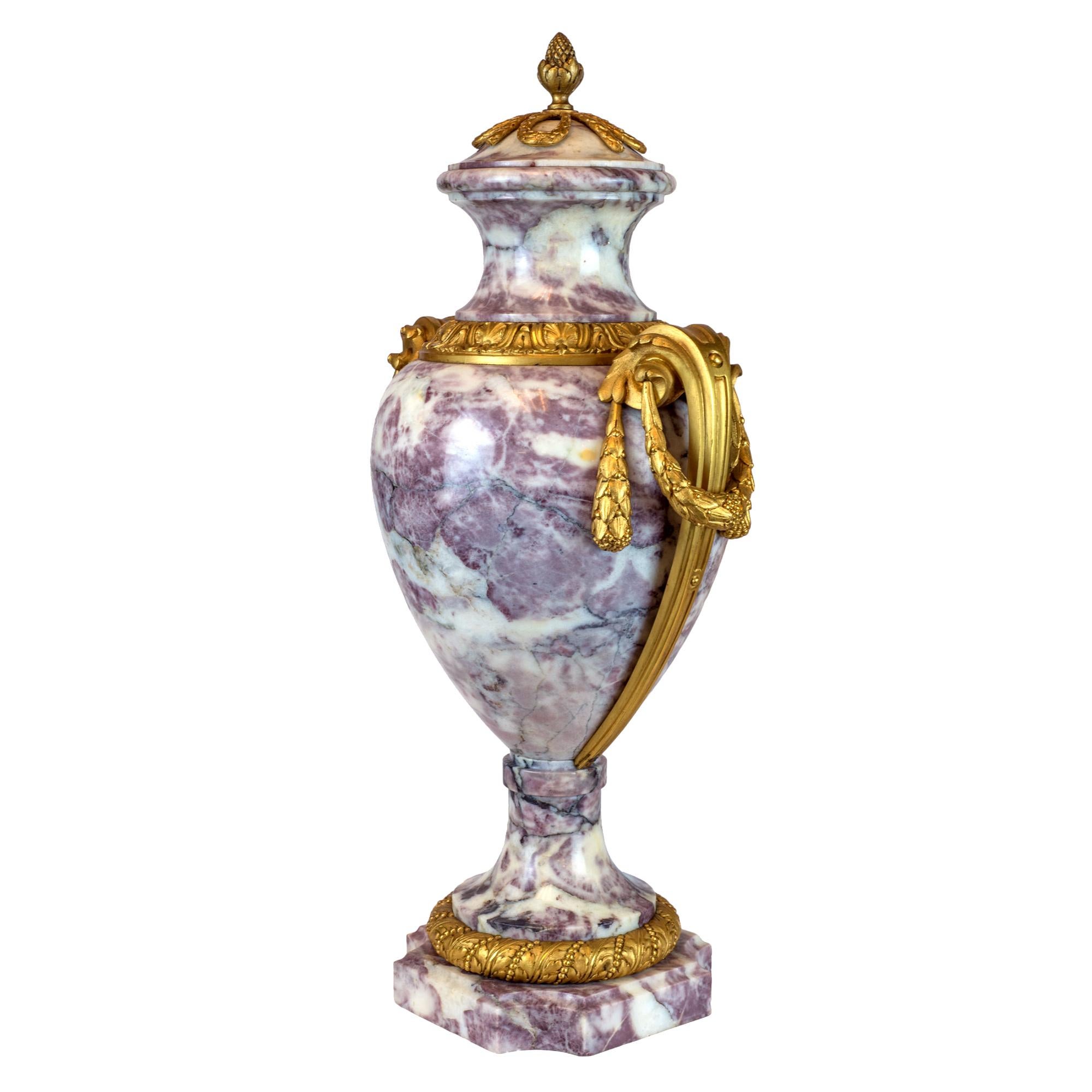 Elegant pair of ormolu-mounted brèche violette marble covered urns. Each of baluster shape. The dome cover with foliate ribbon finial with cast mounts handles and berry swags above a spreading feet. Raised on a conforming circular base and square