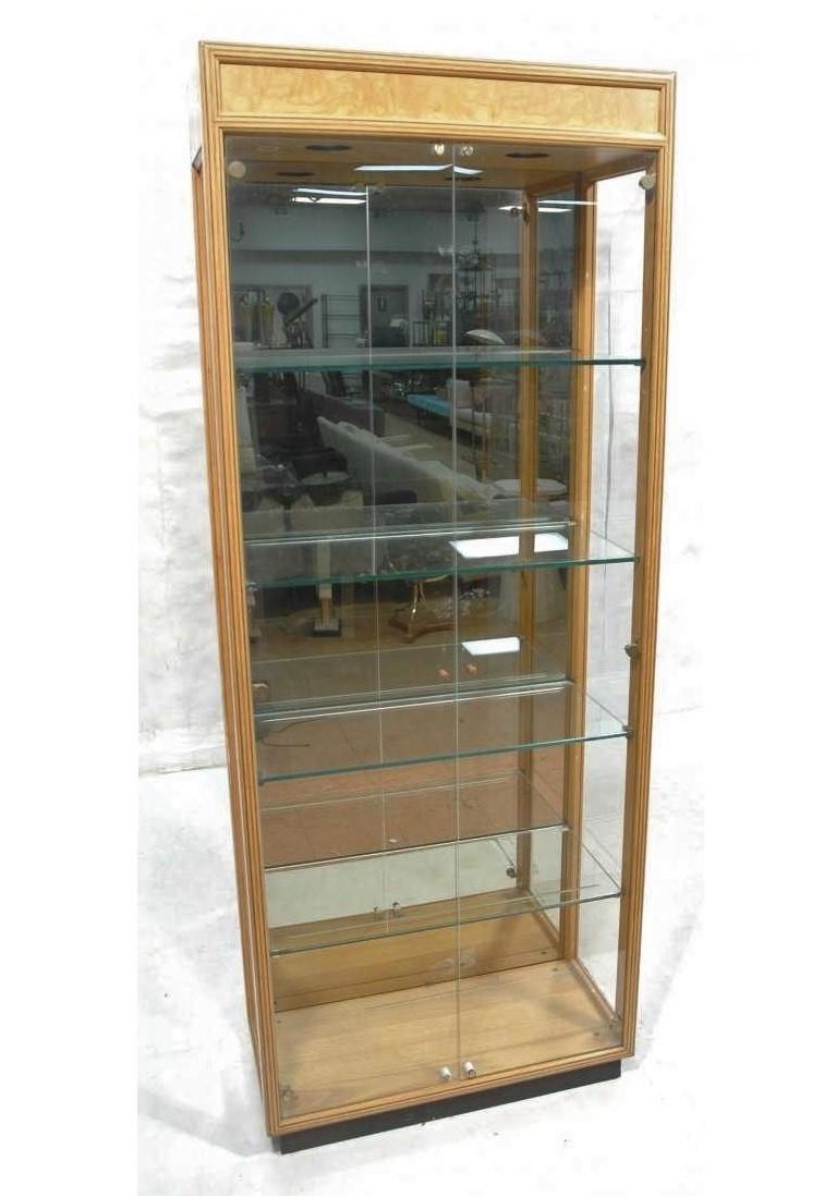 From Henredon Furniture Company's high-end Scene Two line. Pair of honey-colored burl wood curio display cabinets with lighted interior and glass shelves and doors on ebonized plinth bases.