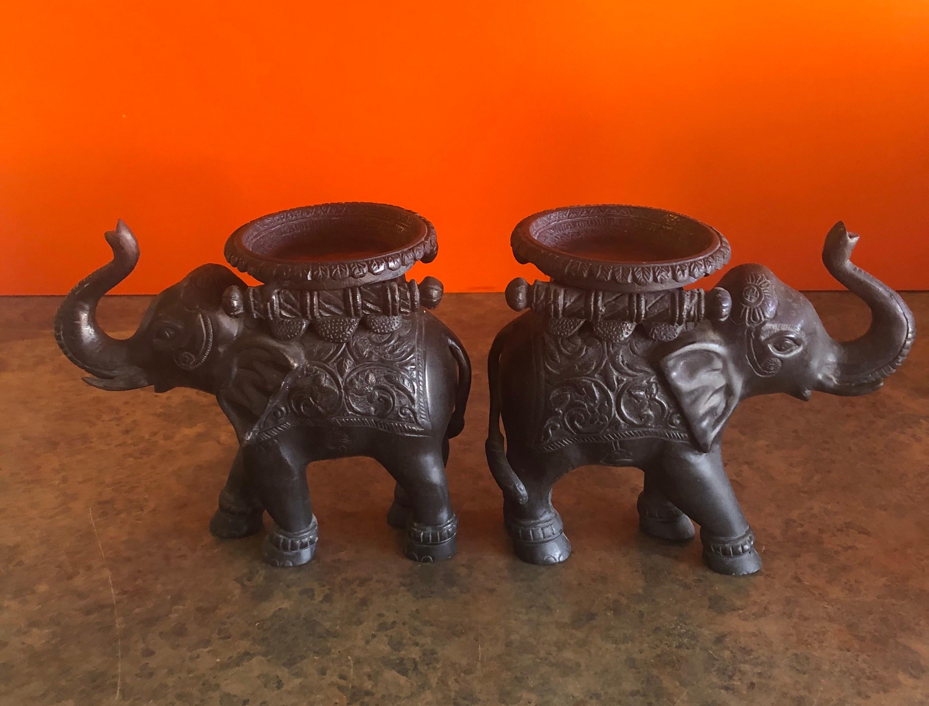 Elegant pair of elephant candleholders in cast bronze, circa 1970s. Each holder measures 8.5