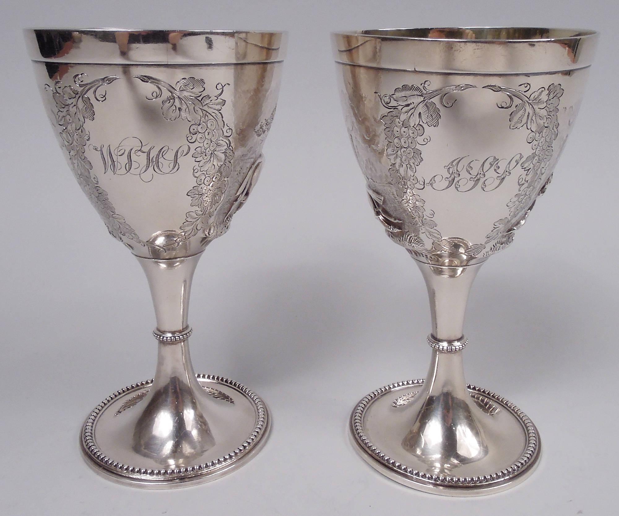Pair of Victorian sterling silver goblets. Make by Elkington & Co. Ltd in Birmingham in 1860. Each: Ovoid bowl on knopped stem; raised foot. Chased and engraved horse scenes. On one, mounted horses amble through the countryside. On the other, it’s a