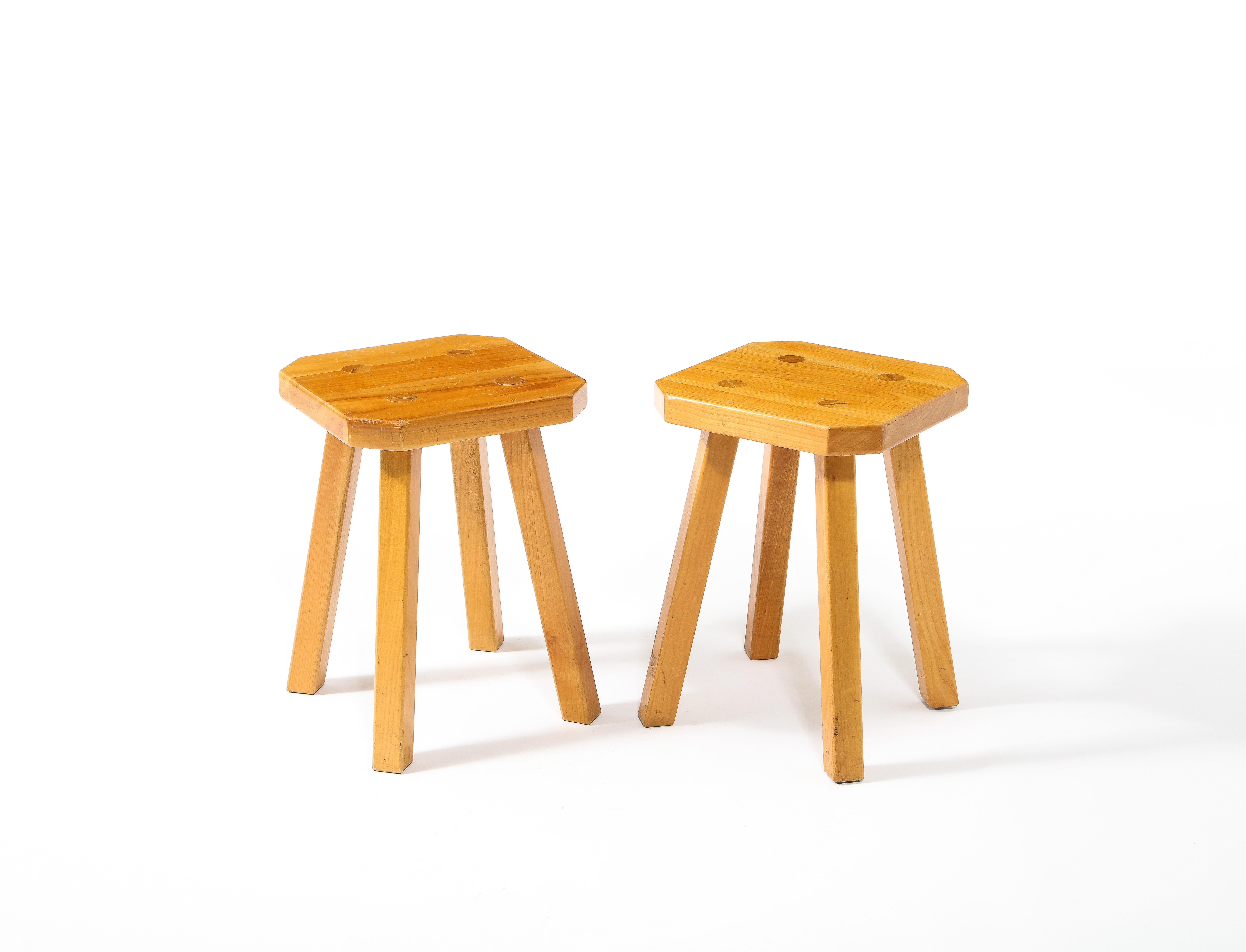 A pair of honey-colored Elm stools with octagonal tops.