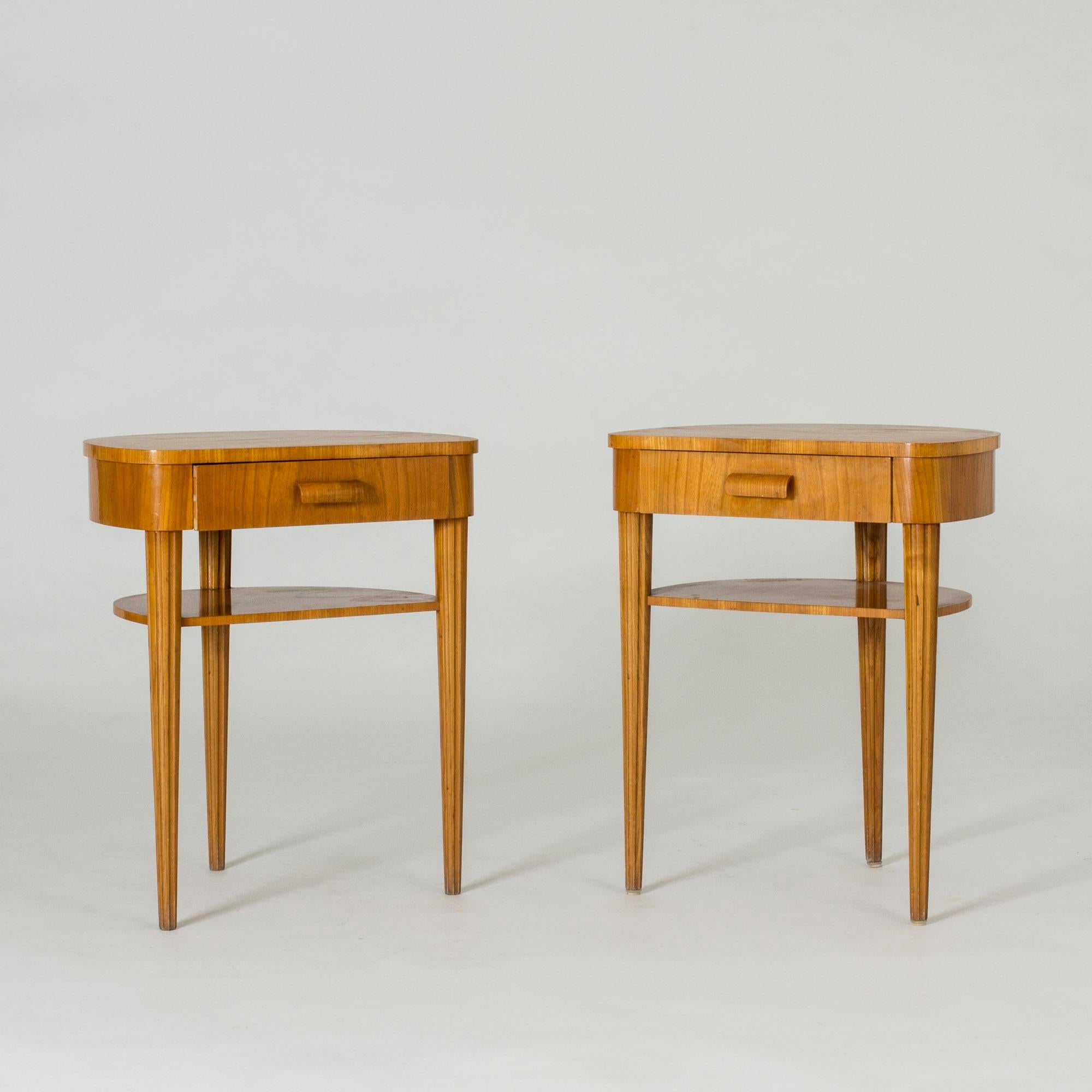 Pair of beautiful elmwood bedside tables from Bodafors. Each table has three slender legs embossed with stripes. Drawers with sculpted decorative handles.