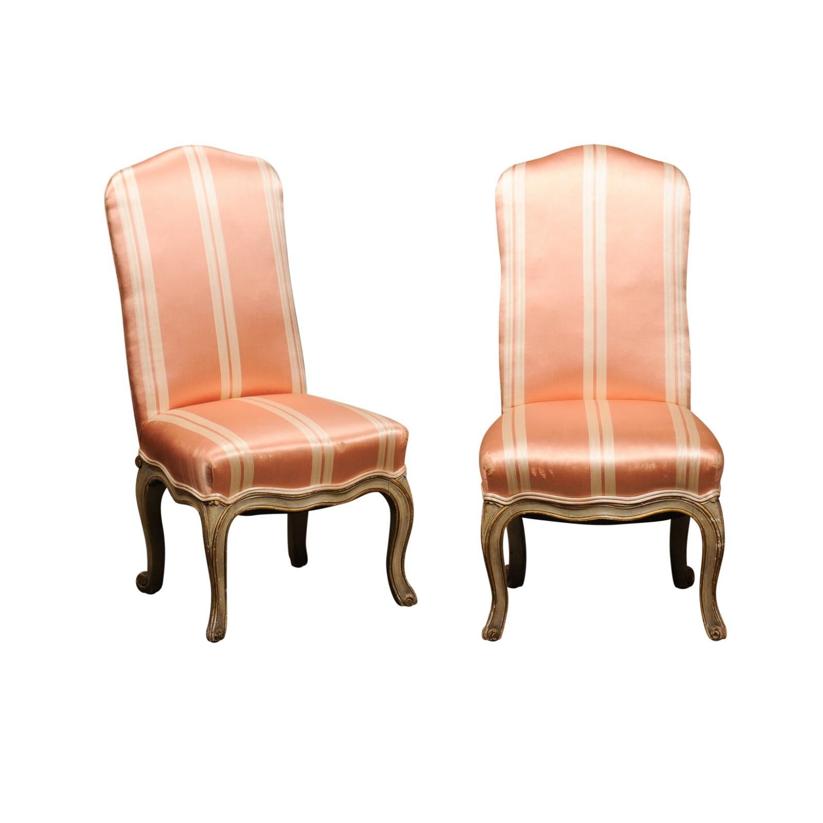 A pair of Elsie De Wolfe Louis XV style slipper chairs from the early 20th century, with cabriole legs and striped salmon upholstery. Made in the USA during the early years of the 20th century, each of this pair of slipper chairs, created by actress