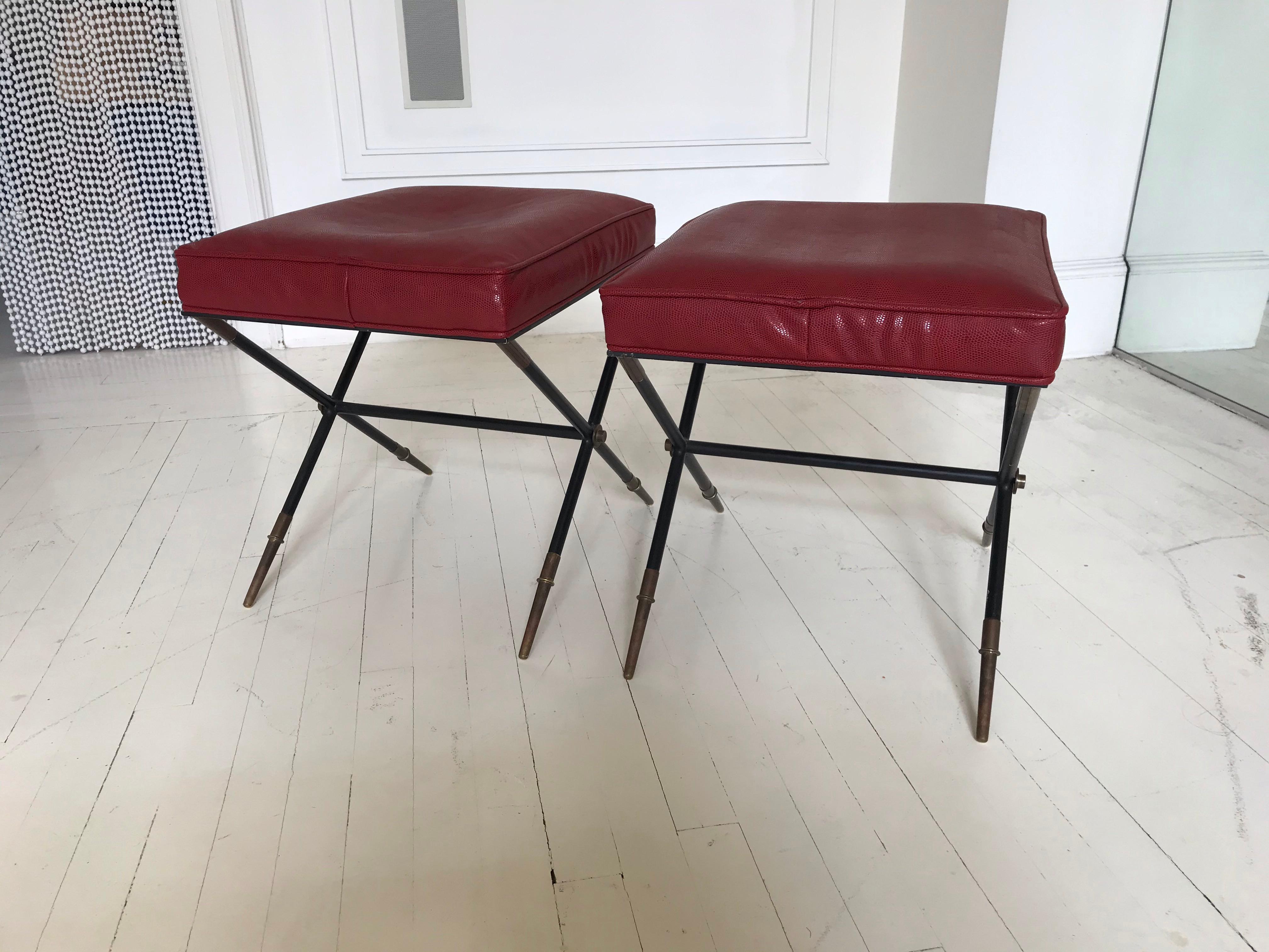 A very rare pair of x-base benches with original embossed leather upholstery and black-finished metal / brass legs.