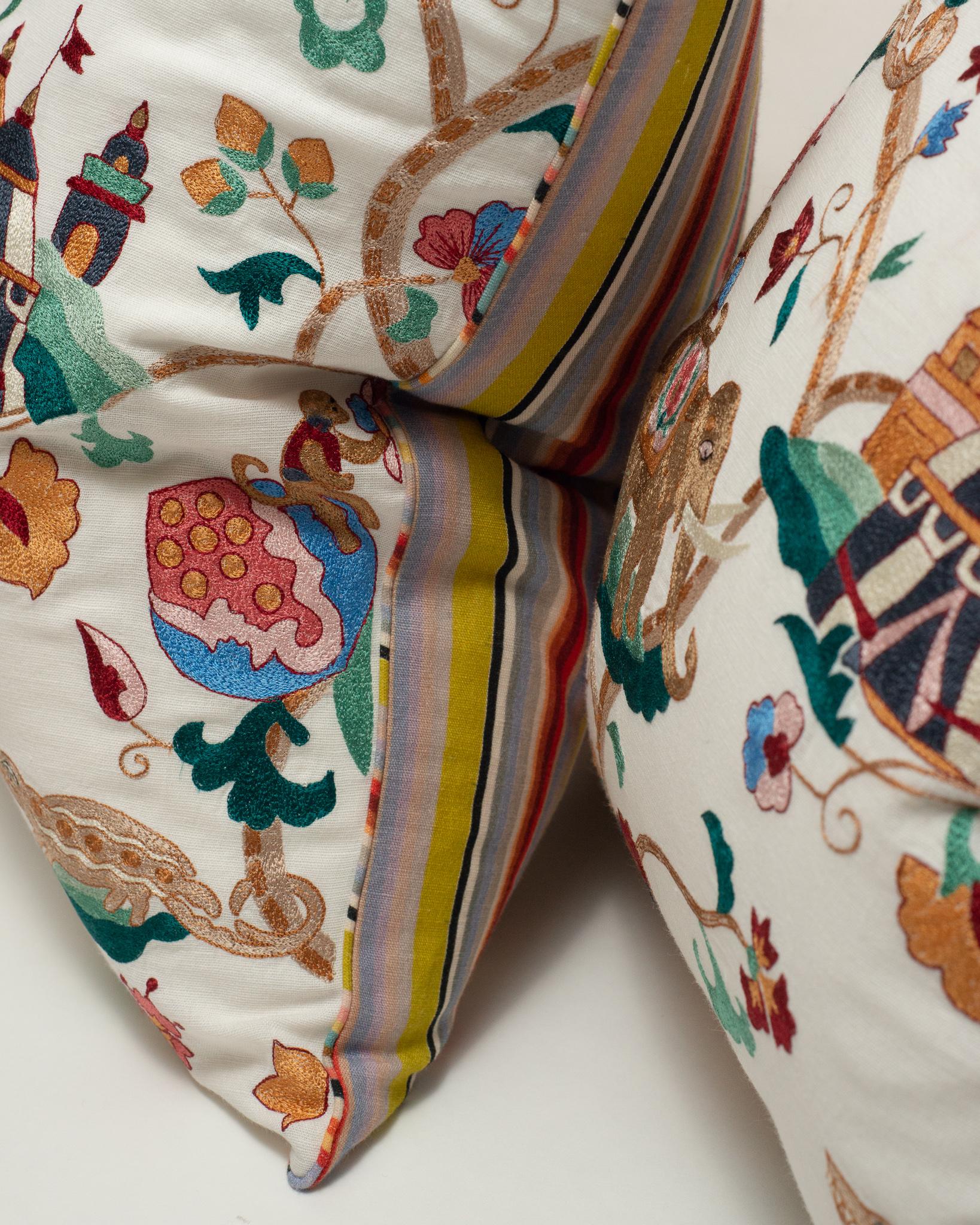 A beautiful pair of embroidered cotton pillows with circus theme motifs. Piped and backed in multicolour striped cotton, and entirely down filled.