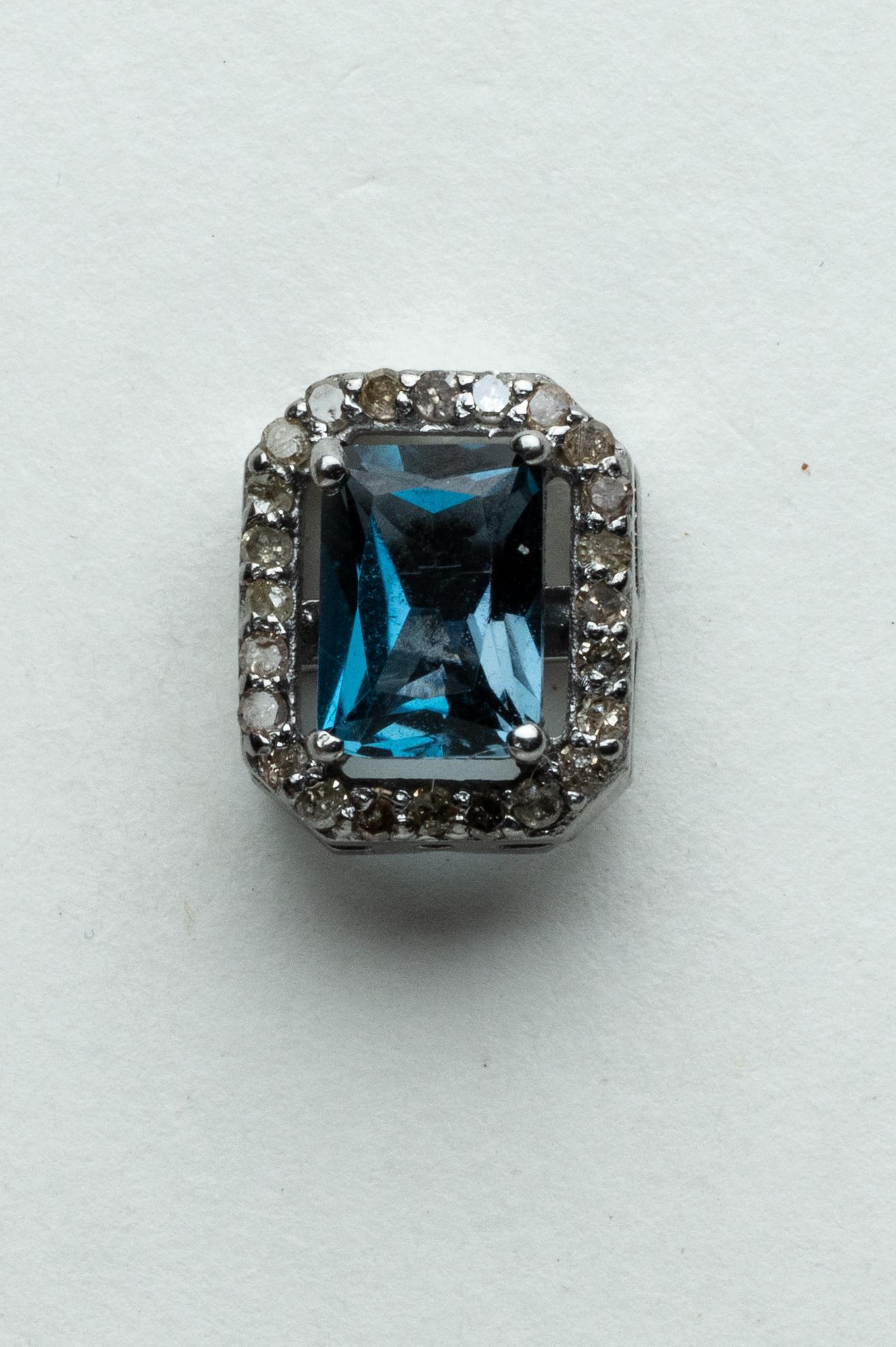 Precioso par de pendientes de topacio azul de Londres, talla esmeralda. Bordeado de diamantes redondos de talla brillante.  Engarzado en plata de ley para orejas perforadas.  Los diamantes suman 0,36 quilates y el topacio azul 2,22