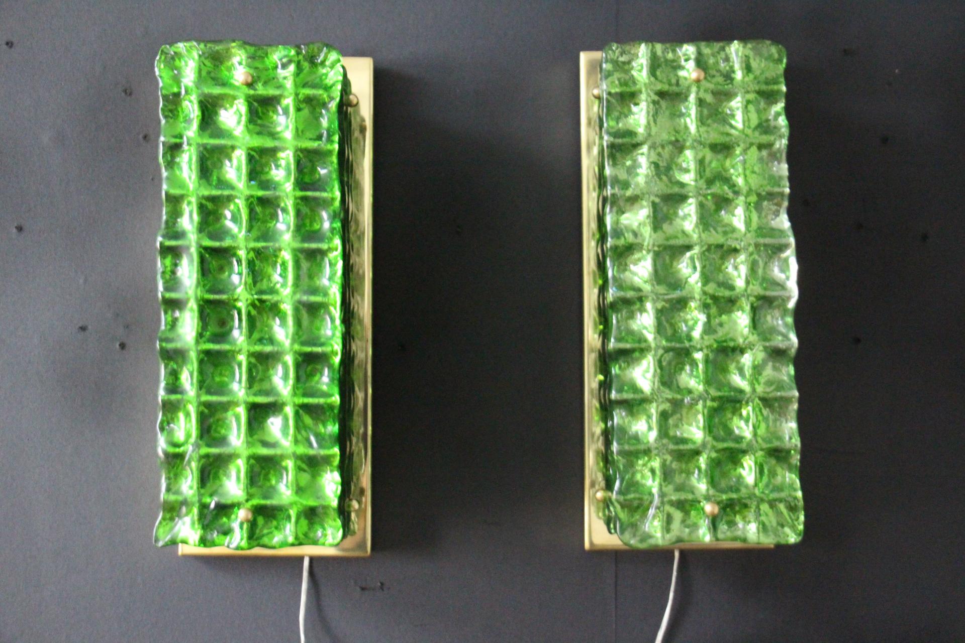 This beautiful pair of sconces has got a very deep emerald color.
All made in textured Murano glass, it features a kind of checkers pattern that is very unique. Pieces of glass have been individually made by hand by a team of very skilled artisans