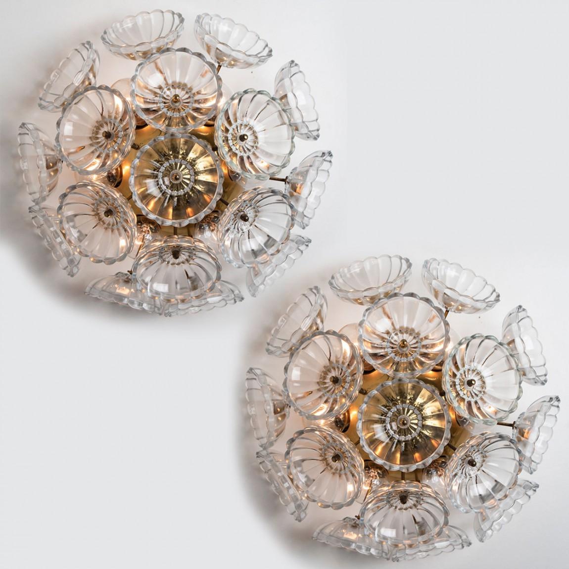Zwei auffällige Wandleuchten aus floralem Glas und Messing von Emil Stejnar, hergestellt in den 1960er Jahren in Österreich.
Die schweren Klarglasblumen sind auf einen Sputnik-Rahmen aus Messing montiert.
Die Glasstücke sind mit viel Liebe zum