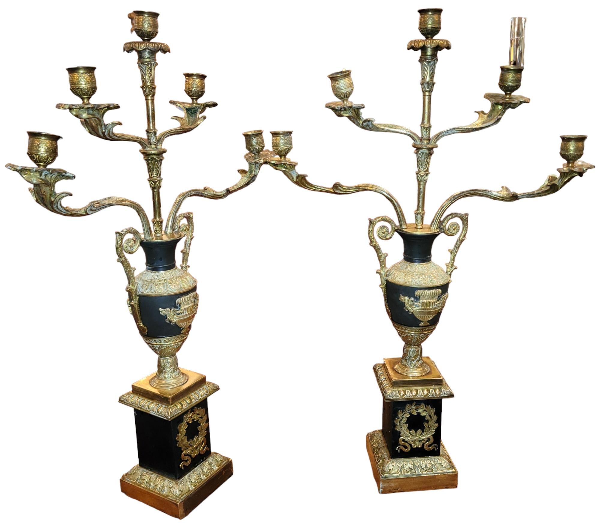 Paar Empire Bronze 5 Light Candle Sticks. Die Kerzenständer werden von einem floral gestalteten Kerzenhalter gekrönt. Das zentrale Design ist das einer Urne mit Vögeln an den Seiten. Das untere Design ist ein Kranz. Tolles, durchdachtes Design und