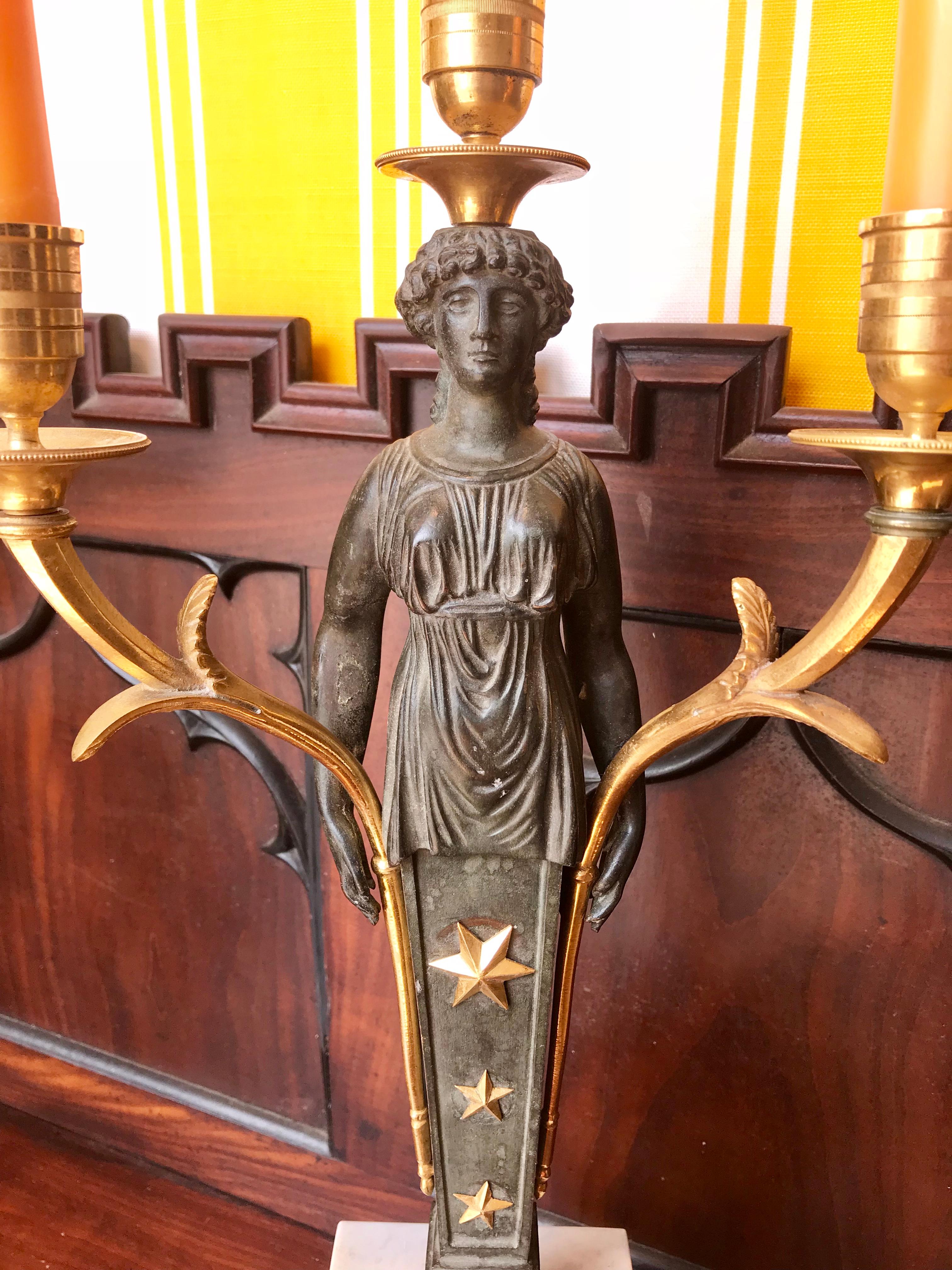 Pair of late 19th century Empire bronze and ormolu candelabra.

- Caryatid herm female figures on marble block plinths.
- Three ormolu candle arms/cups
- Well modeled.