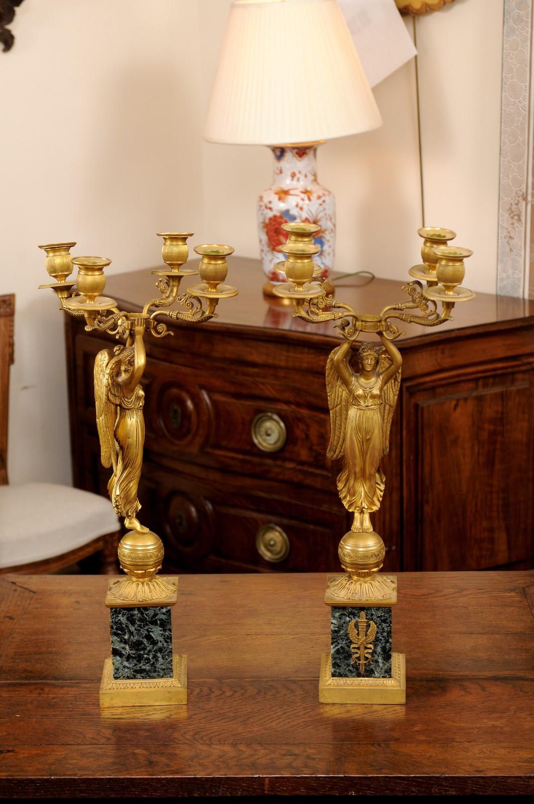 These pair of Empire candelabras feature angles holding 4 candleholders atop a green marble base.