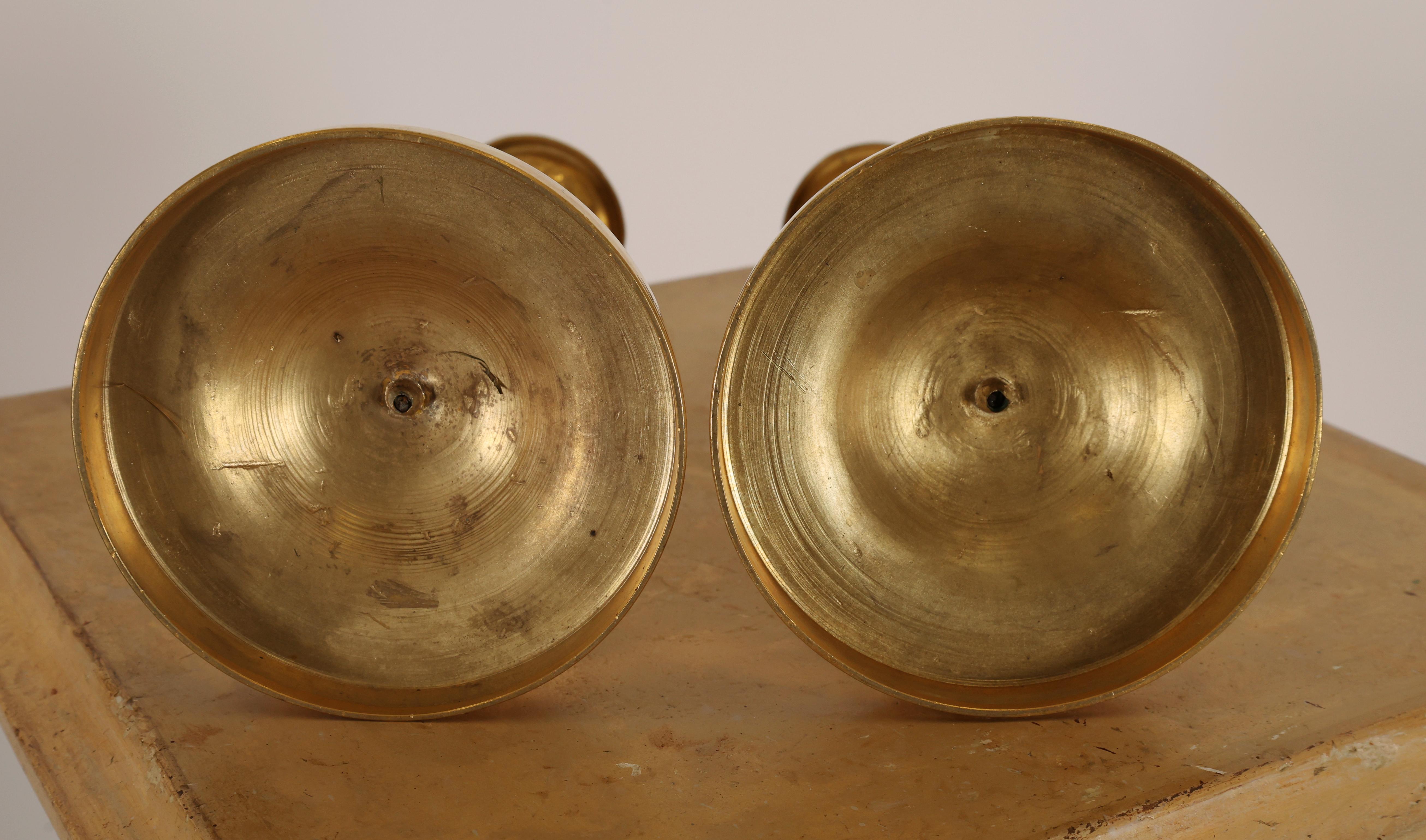 Coppia di portacandele Impero francese in bronzo dorato a fuoco. Presentano decorazioni di scanalature e foglie d'acanto. I manicotti delle candele sono rimovibili.