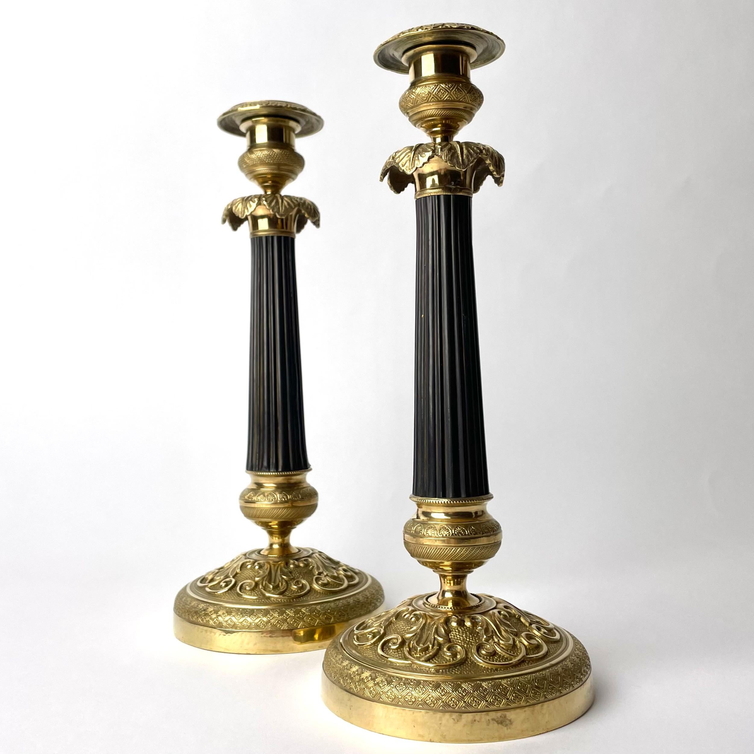 French Pair of Empire Candlesticks in gilded and darkpatinated bronze from the 1820s For Sale