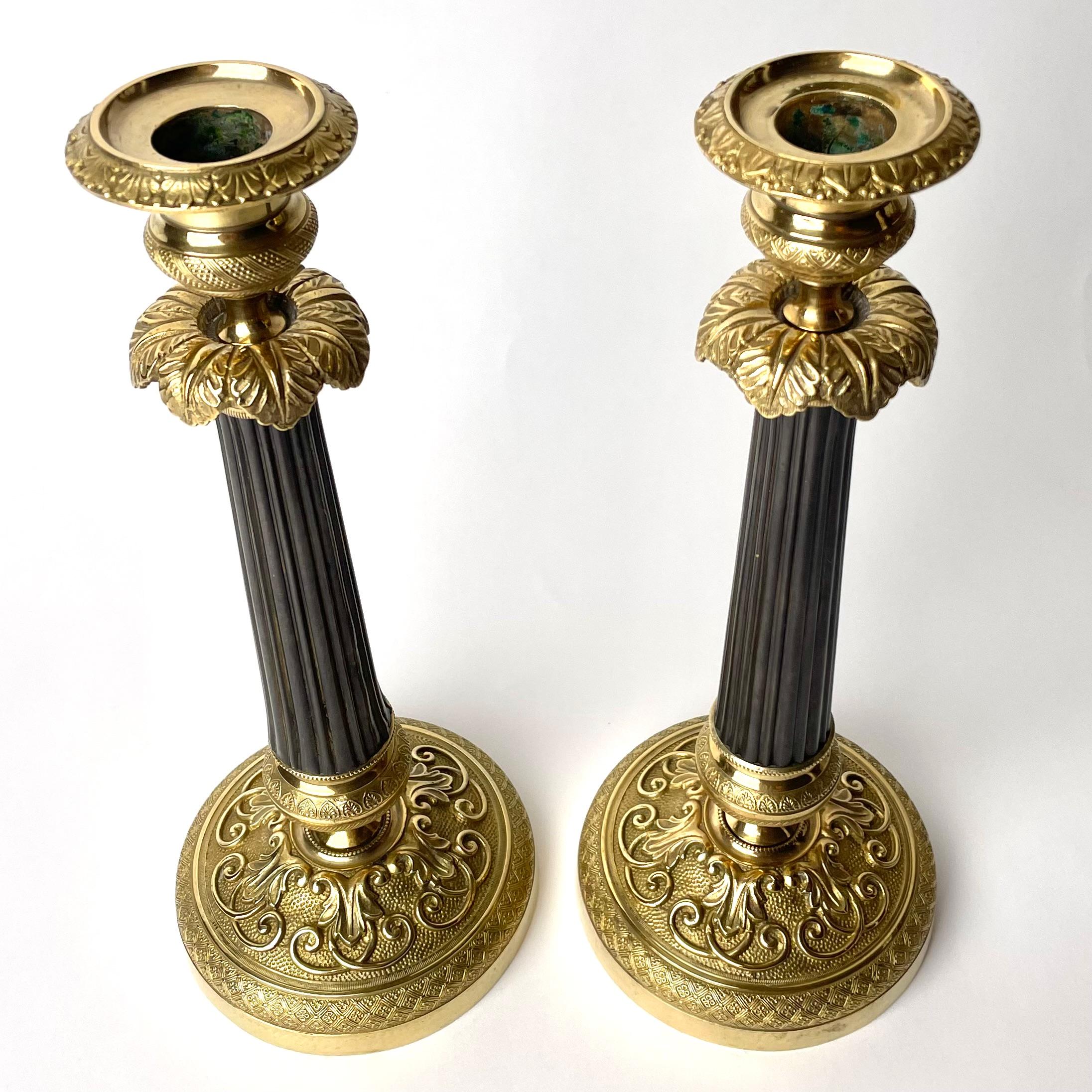 Gilt Pair of Empire Candlesticks in gilded and darkpatinated bronze from the 1820s For Sale
