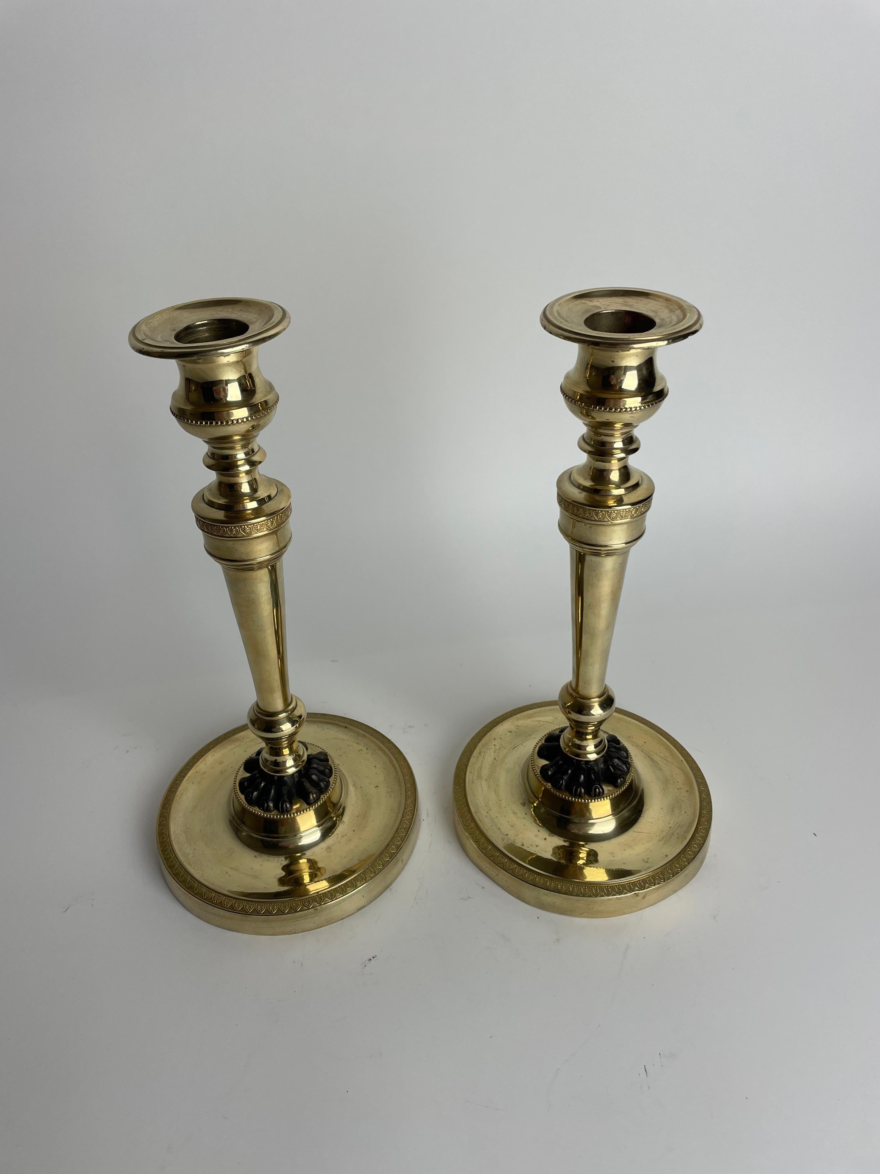 Francese Coppia di candelieri Impero in bronzo dorato con zampe di leone patinate scure. 1810s in vendita