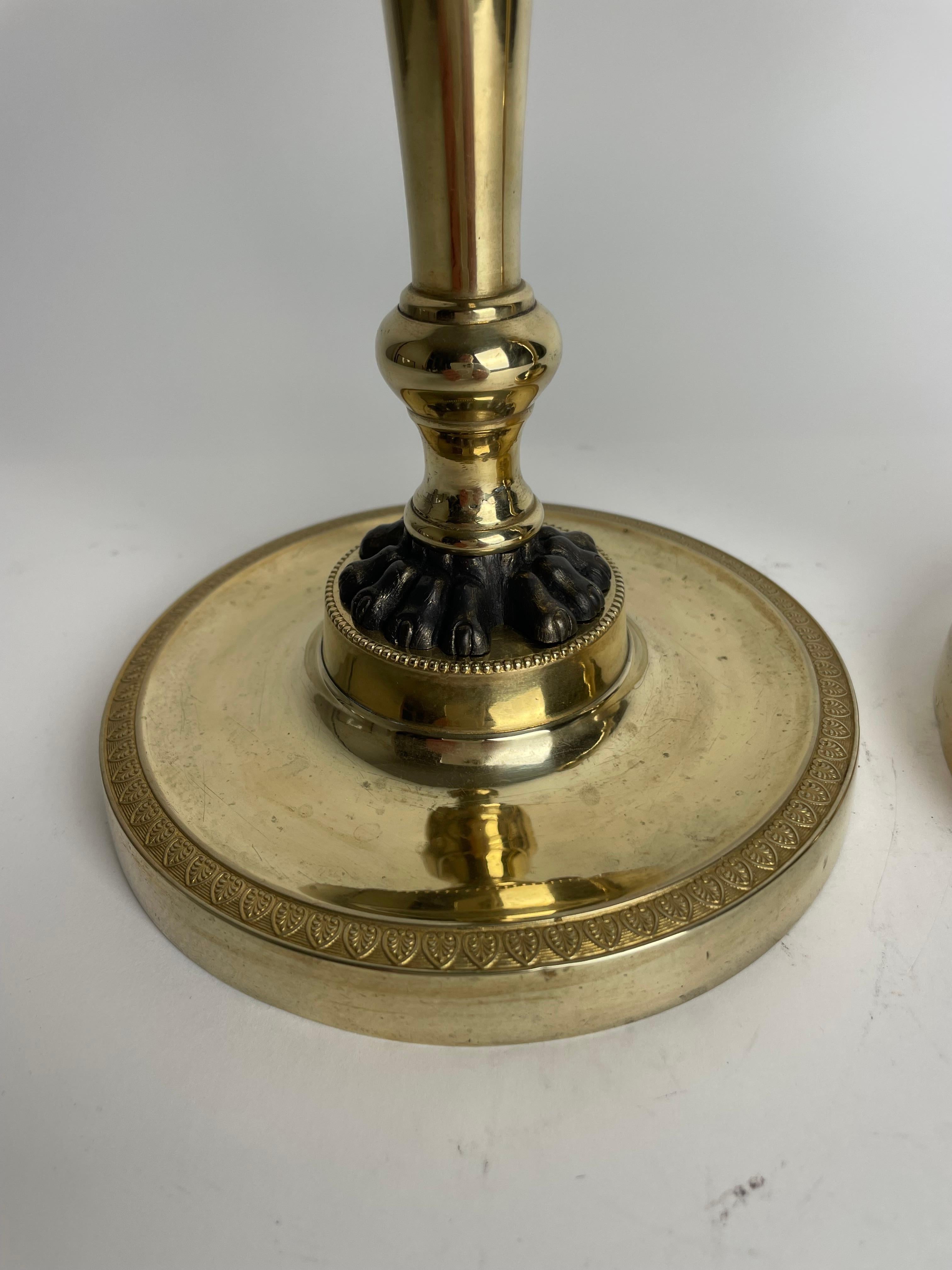 Dorato Coppia di candelieri Impero in bronzo dorato con zampe di leone patinate scure. 1810s in vendita