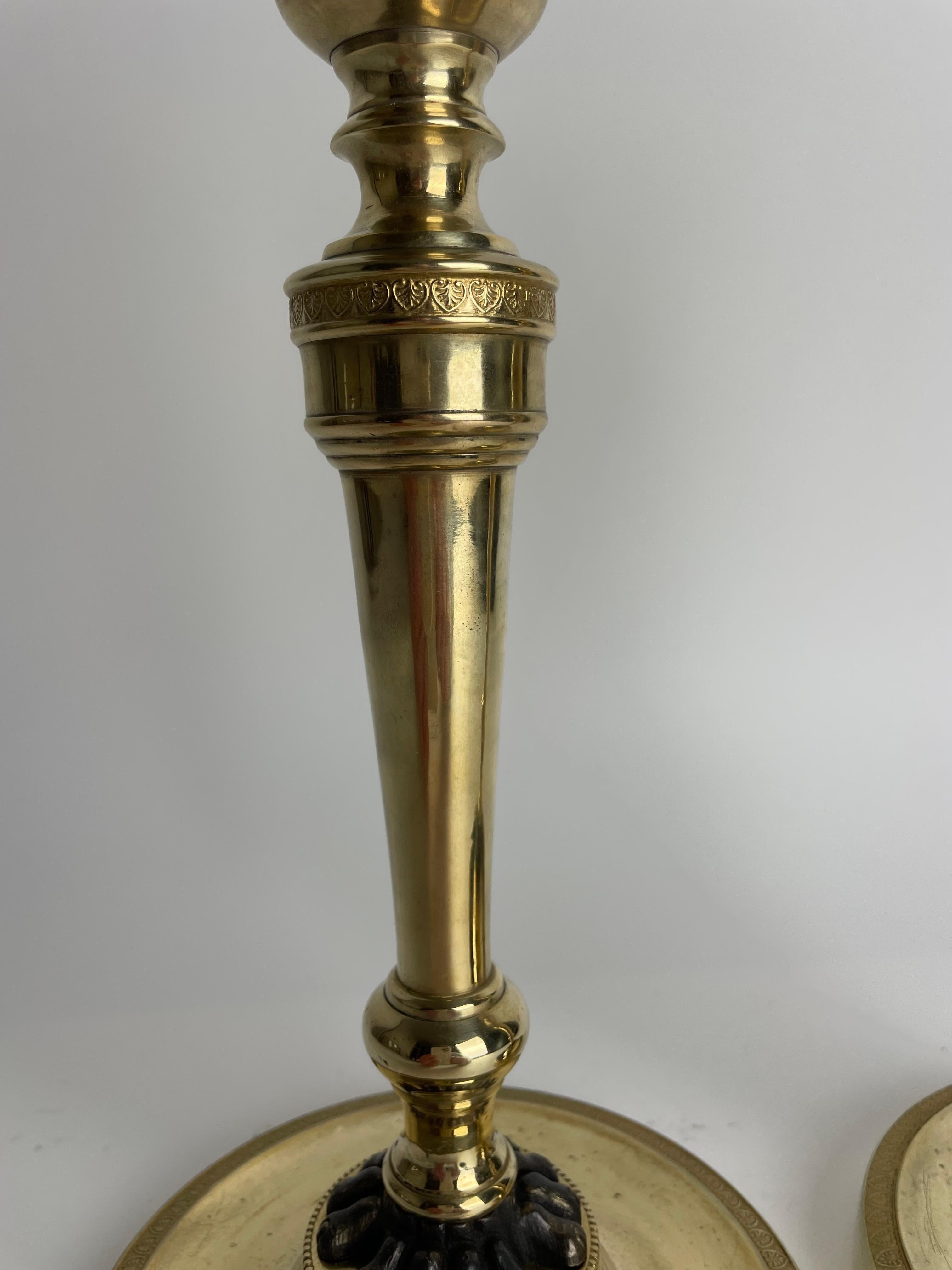 Inizio XIX secolo Coppia di candelieri Impero in bronzo dorato con zampe di leone patinate scure. 1810s in vendita