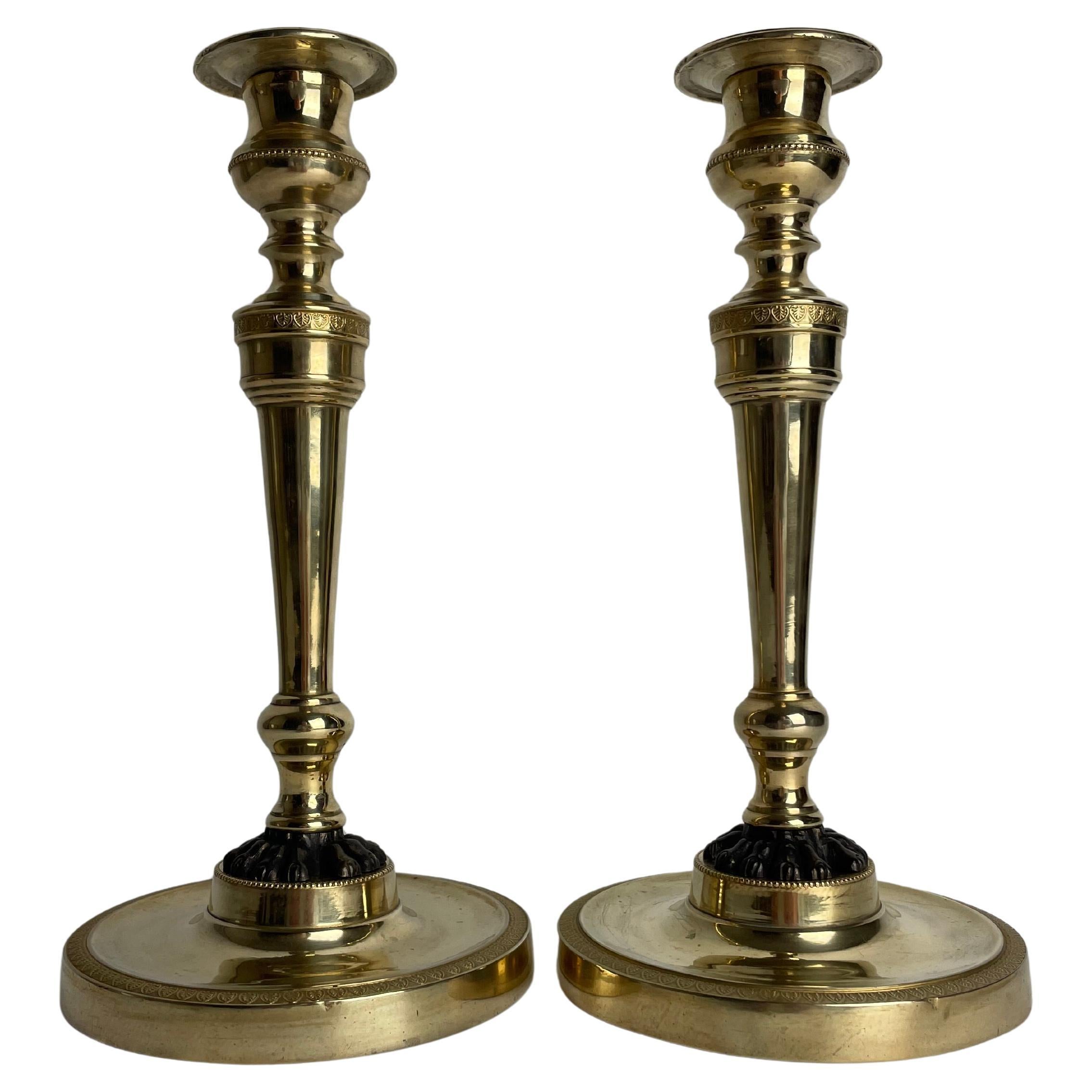Pareja de candeleros imperio de bronce dorado con patas de león patinadas en oscuro. 1810s