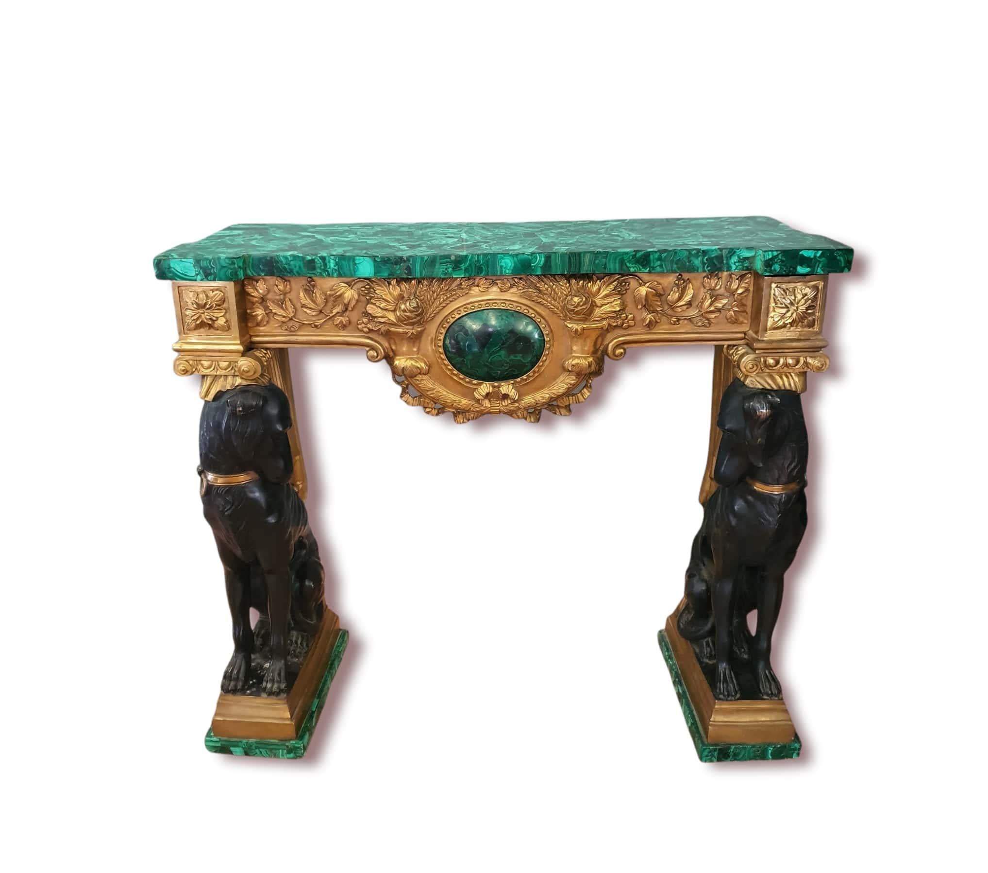 Important pair of consoles, made of patinated bronze and finely chiseled and gilded bronze. At the base we find two flowered malachite bases where two dogs rest, made of patinated and gilded bronze, looking at each other, and supporting the front
