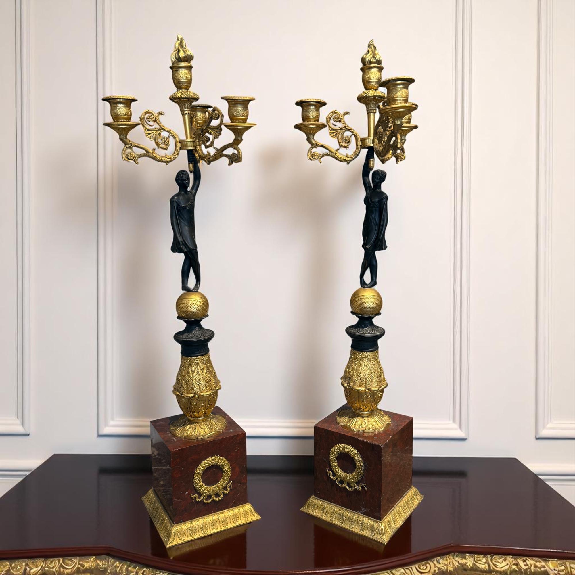 Excepcional pareja de candelabros de la época Imperio, de principios del siglo XIX, hacia 1810. Esta pareja de gran refinamiento es emblemática del apogeo del estilo Imperio, encarnando la elegancia y la grandeza neoclásica características de la