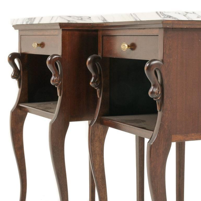 A pair of French Empire-style nightstands in mahogany, with carved swan details and marble tops. 

circa 1950.






    