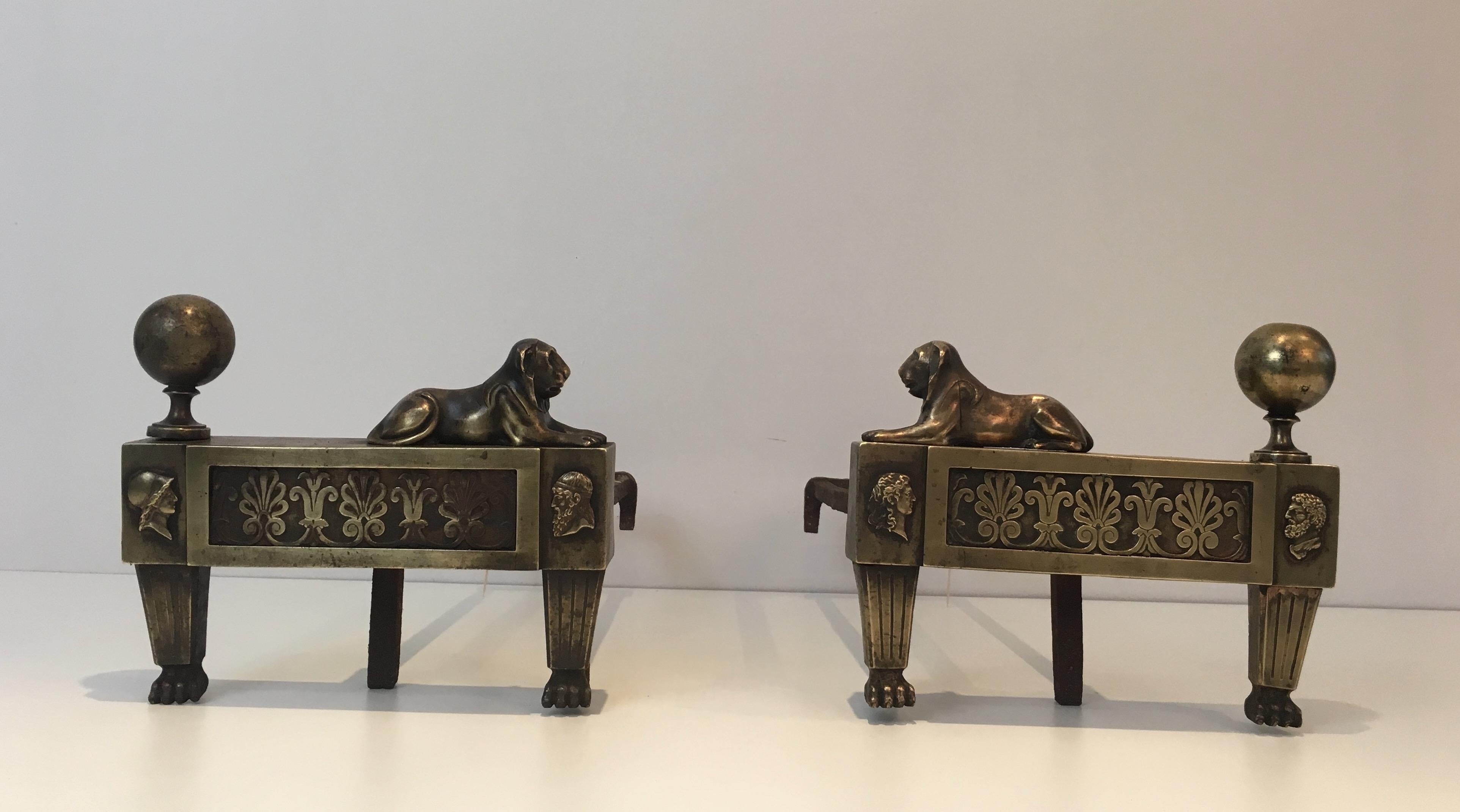 These andirons are made of bronze with lions lying face to face. This is a French Empire period pair of fireplace andirons, circa 1850.