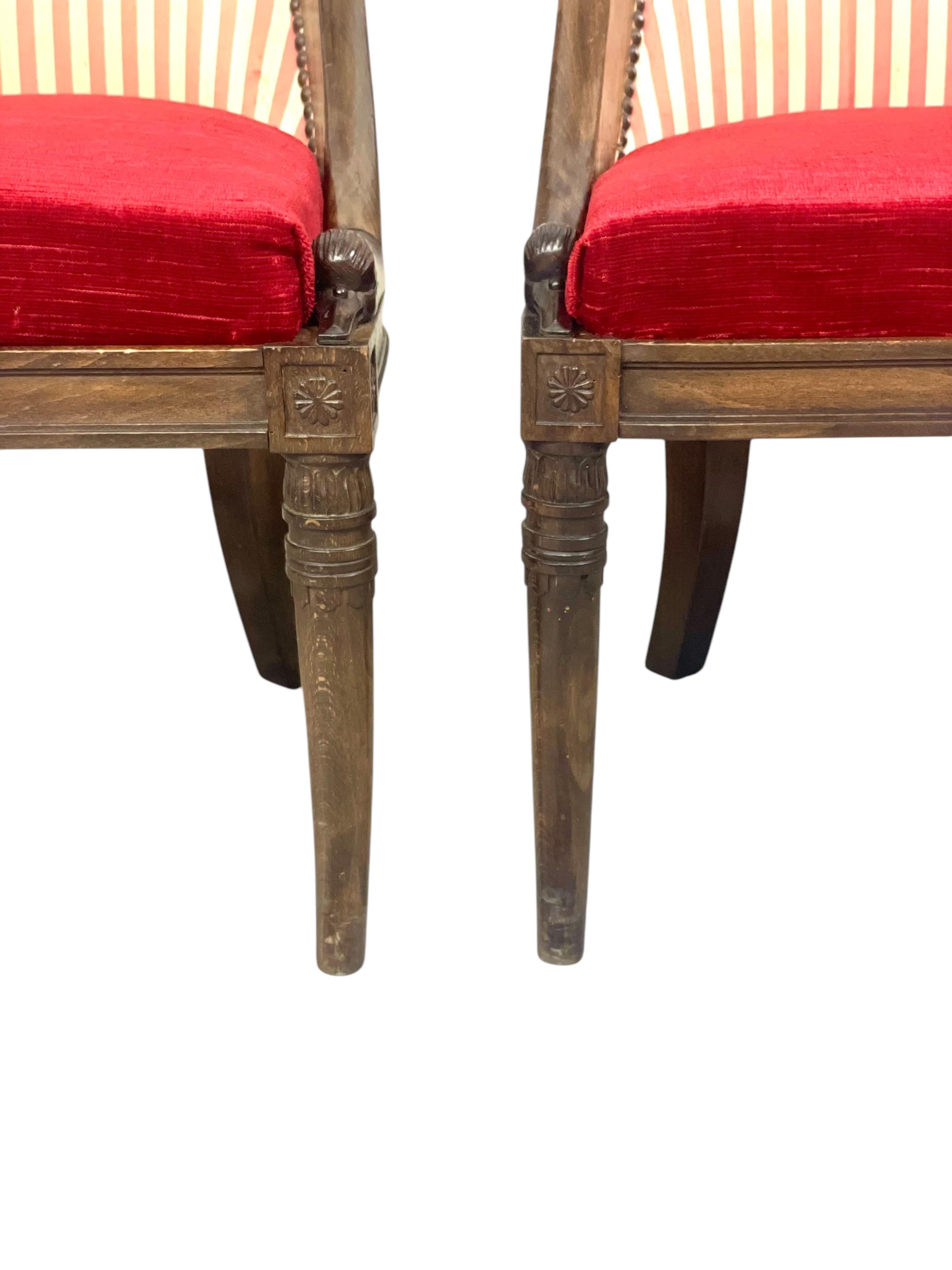 This exquisite pair of children's chairs embodies the elegance and sophistication of the 19th-century Empire Period. Crafted from fine veneers and intricately carved wood, these chairs feature the distinctive gondola-shaped backs that are