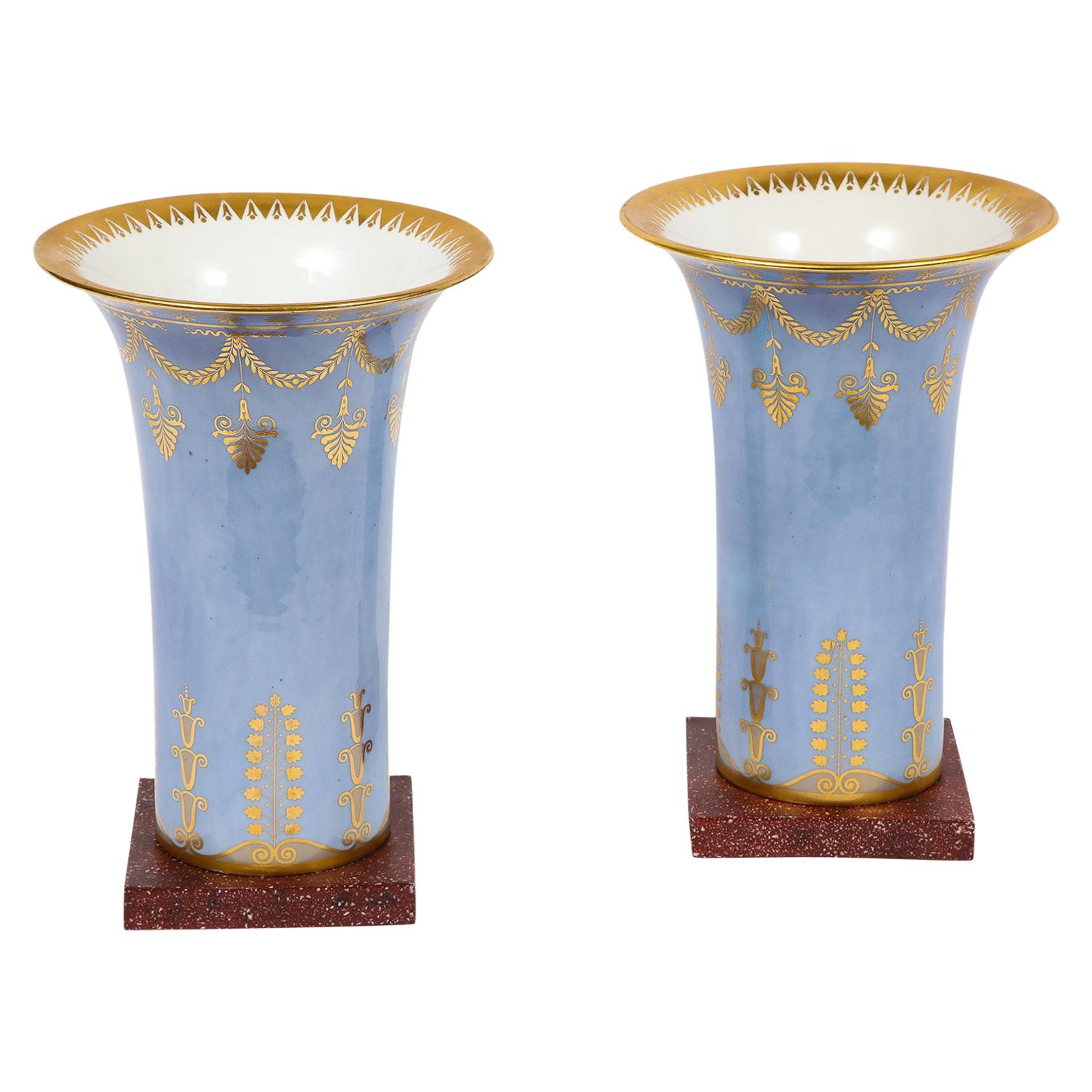 Paire de vases d'époque Empire en porcelaine de Sèvres bleu pâle et faux porphyre sur fond