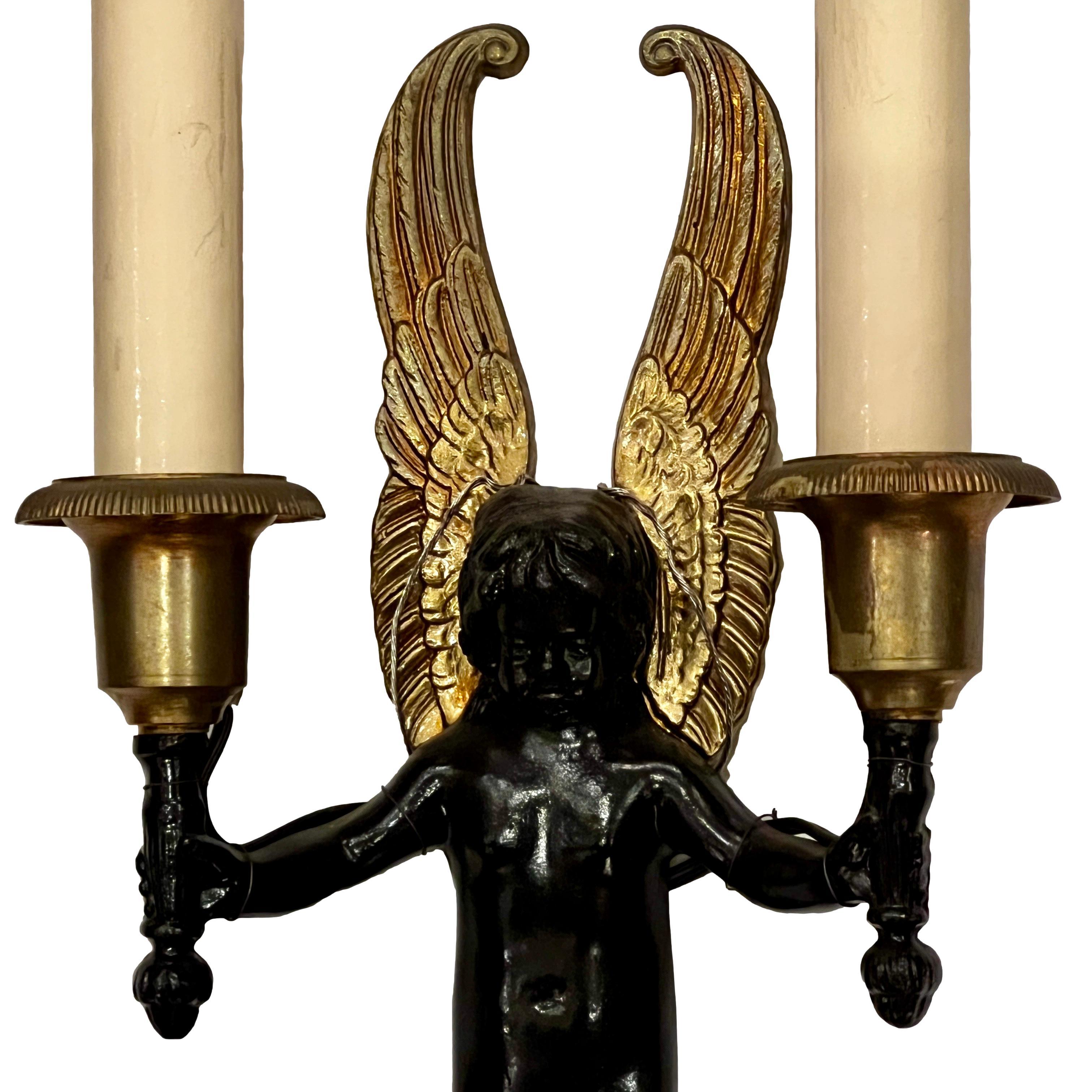 A pair of circa 1920's French bronze Empire-style figural sconces.

Measurements:
Height 13.5