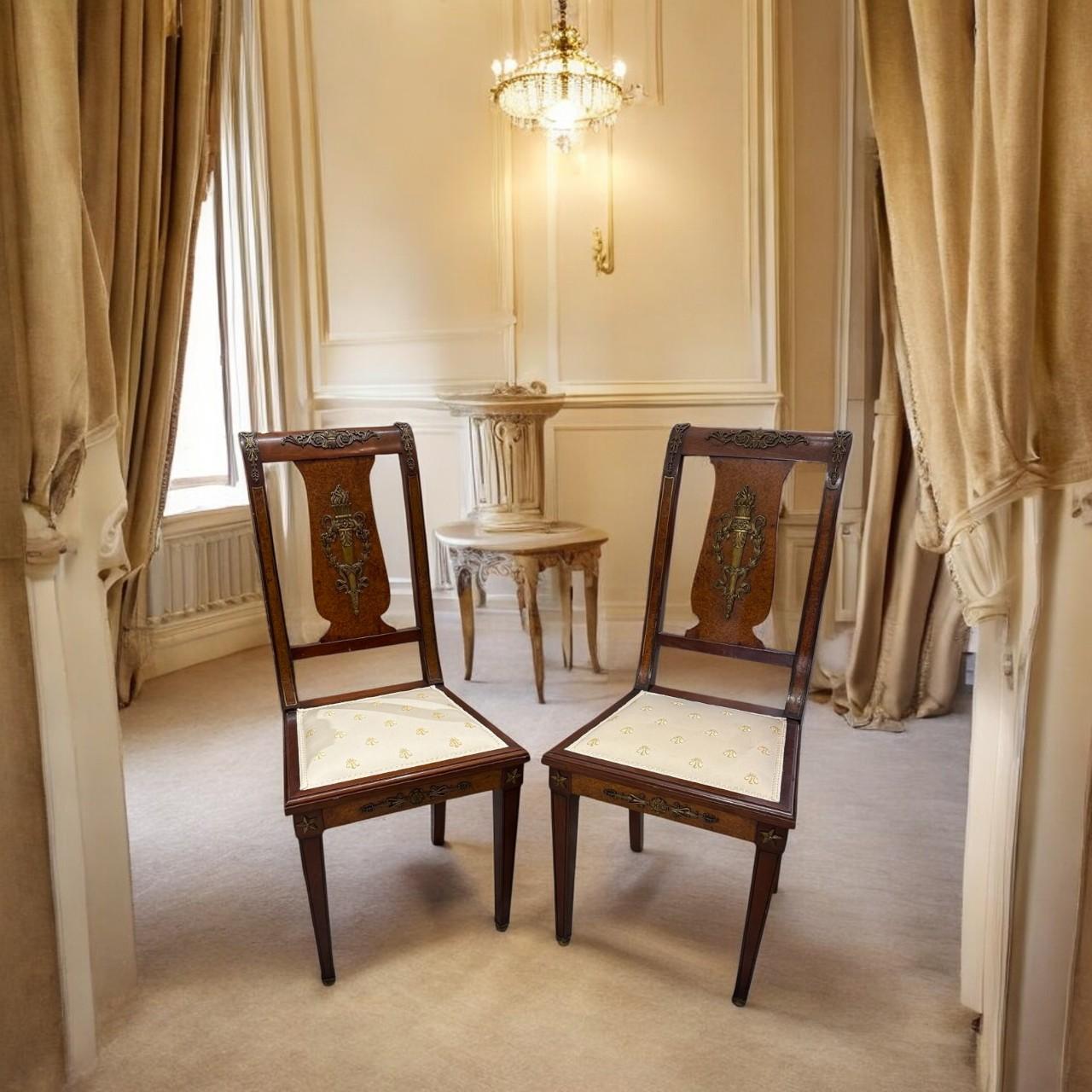 Paire de chaises d'appoint Empire du XIXe siècle.

Réalisées en acajou et en noyer, ces chaises sont élégantes et finement décorées d'ornements classiques en bronze doré caractéristiques du style Empire : palmettes, flambeaux, étoiles, etc.

Les