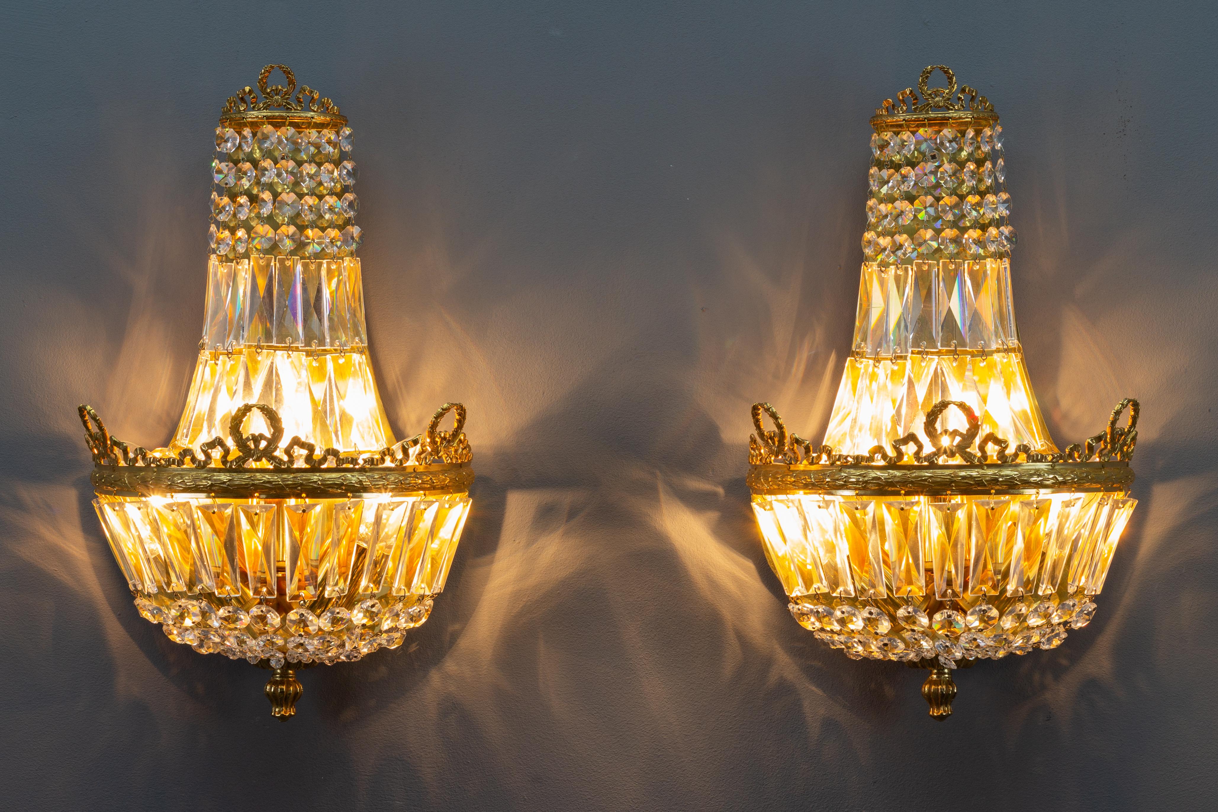 A splendid pair of Empire-style sconces by Palwa, Germany, 1960s. Gilt brass frame adorned with crystal glass beads and prisms, three interior lights for E14 size light bulbs.
Dimensions:
Height: 39 cm / 15.35 in; width: 22 cm / 8.66 in; depth: 13