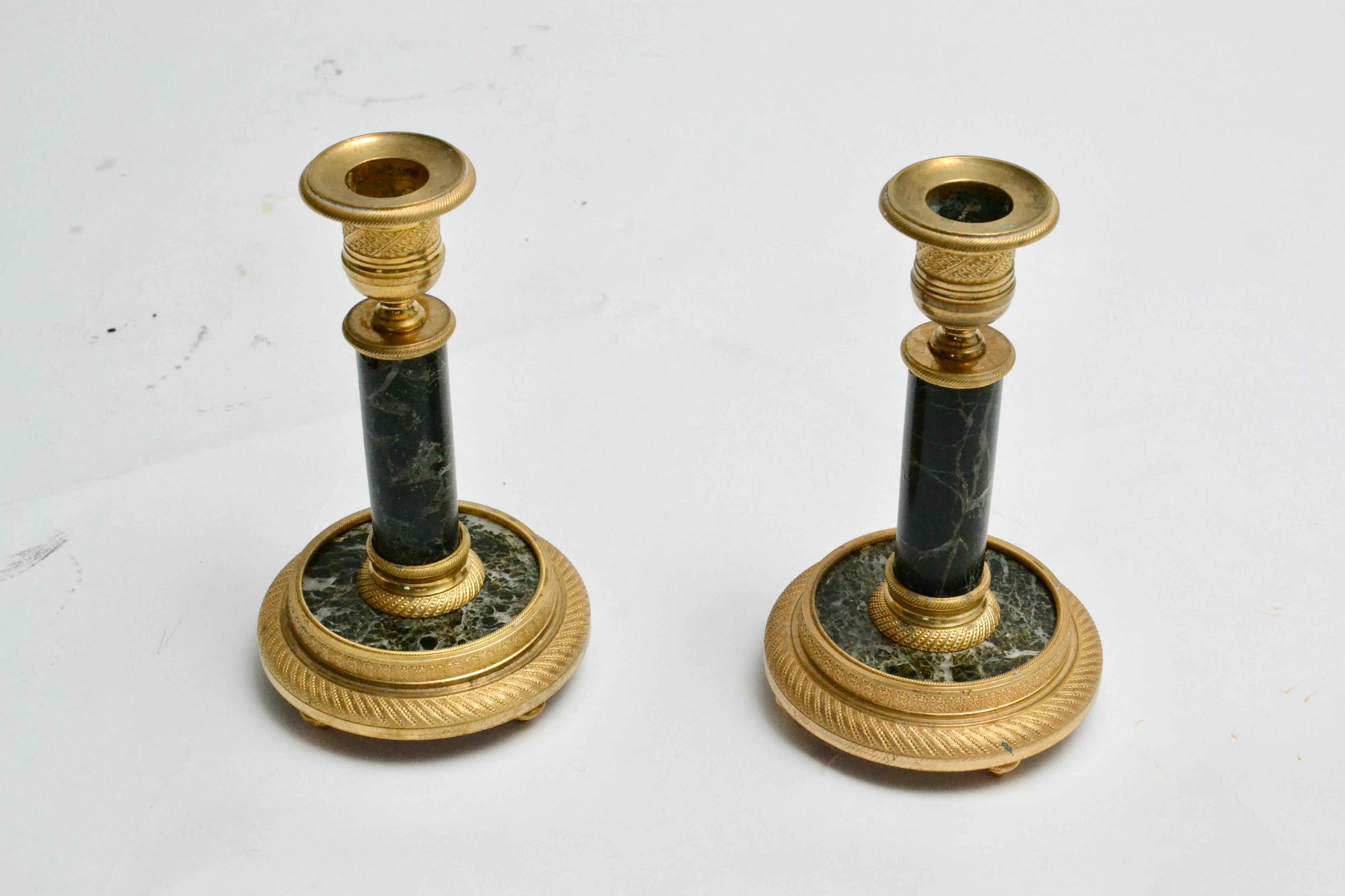 A decorative pair of empire style candlesticks in gilt bronze and dark green marble. France, end of the 19th century. Nice condition. 
