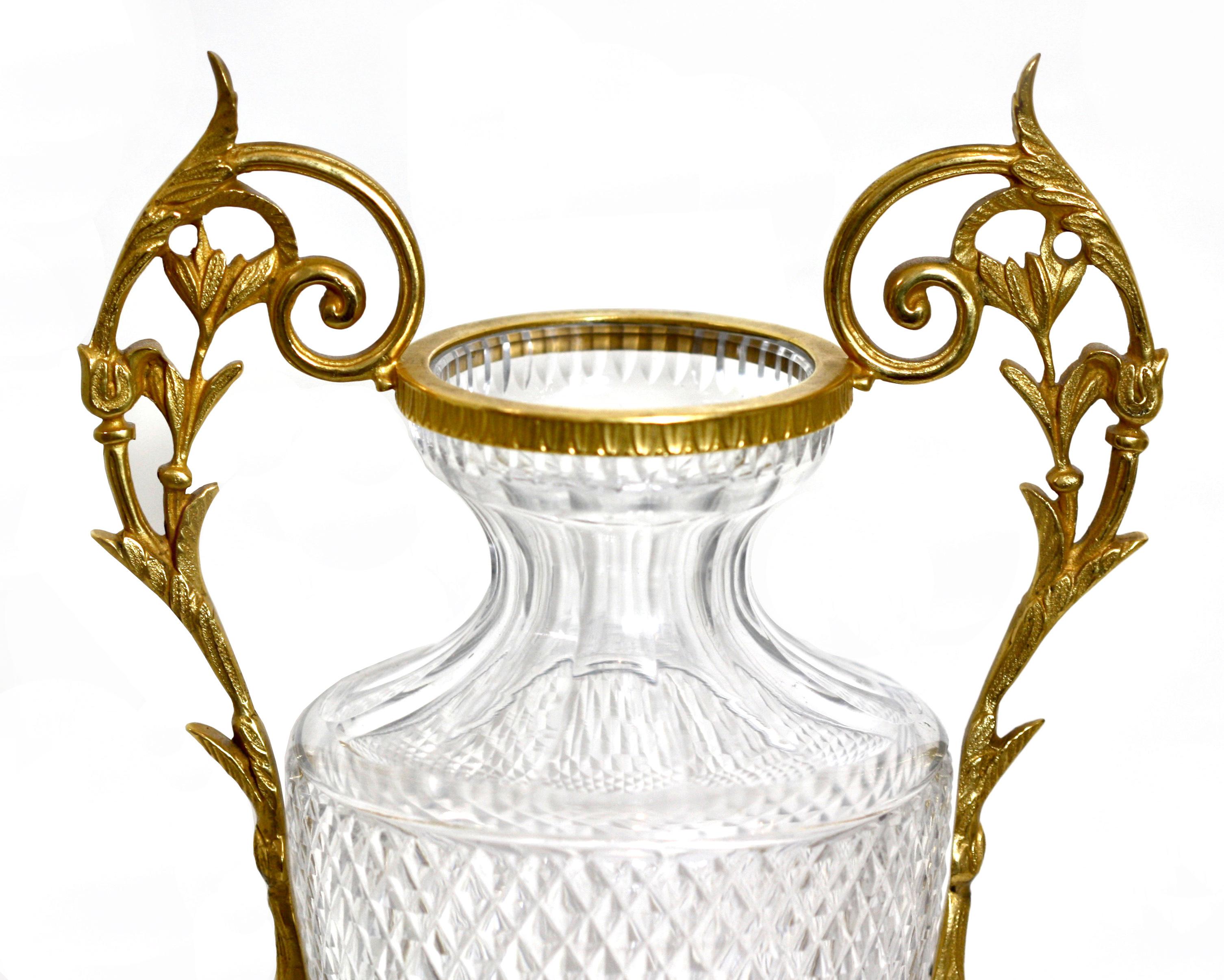 Paar vergoldete Bronze-Urnen im Empire-Stil mit geschliffenem Glas 
20. Jahrhundert. Jede sich verjüngende zylindrische Form wird von Blattwerk flankiert 
schneckengriffe auf einem quadratisch hinterschnittenen Sockel. 
Maße: Höhe 13 in. (33,02