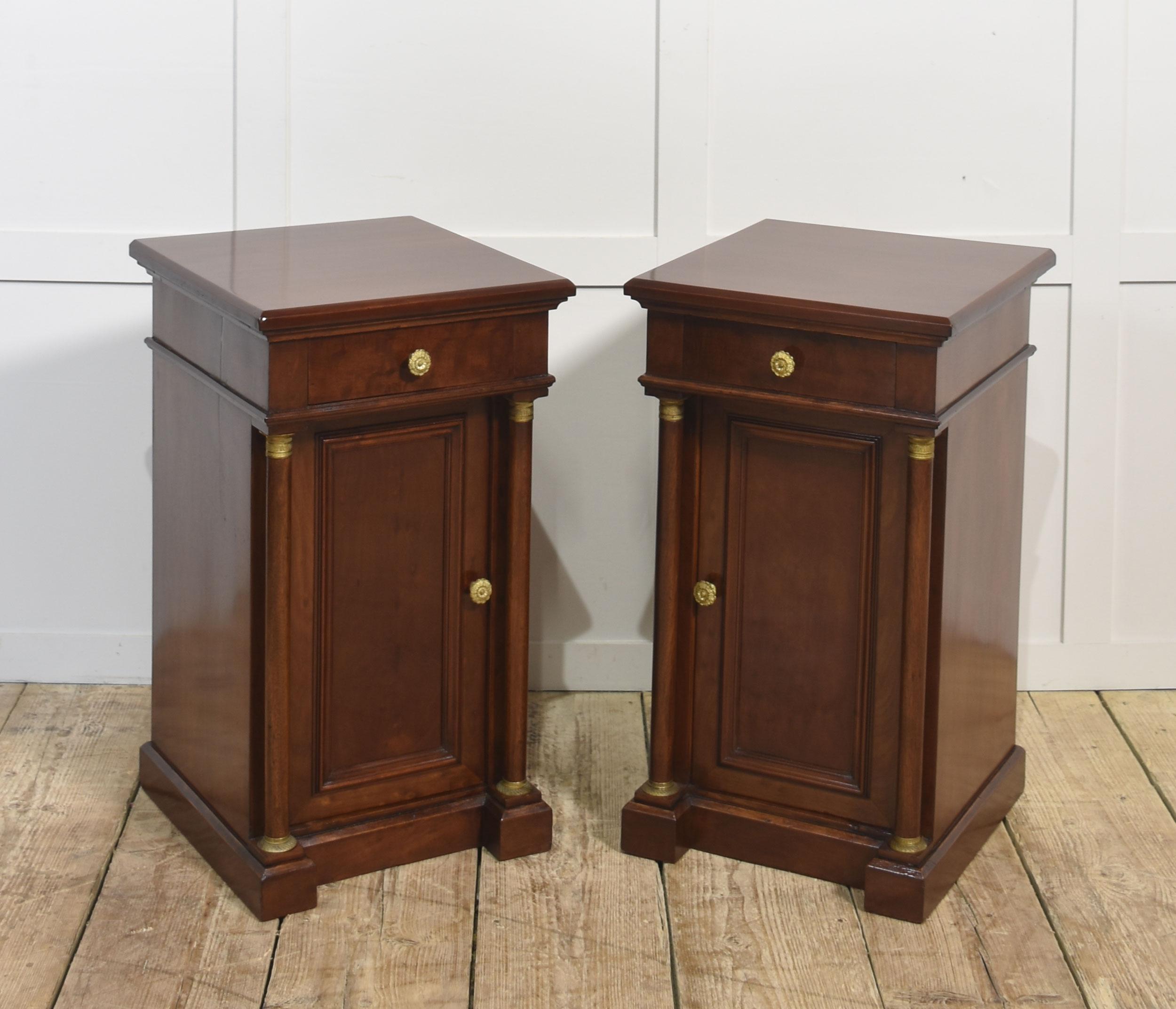 Una bella coppia di comodini in stile Impero, finemente realizzati in ricco mogano con una calda finitura lucida. Ogni mobile è dotato di un cassetto a fregio singolo con maniglia a rosetta in bronzo dorato e di un'anta a pannello che racchiude un