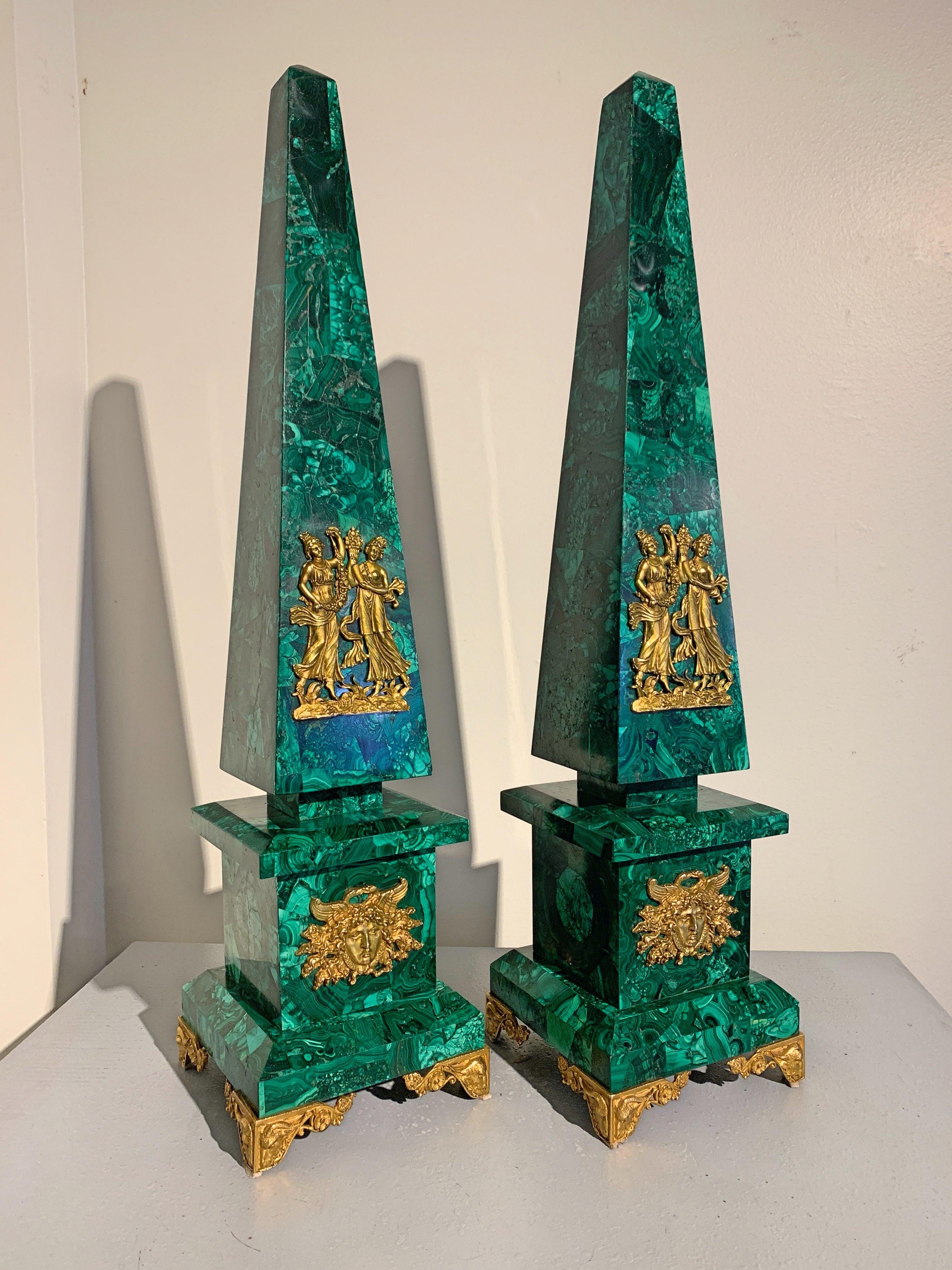 A grand pair of neoclassical style ormolu-mounted malachite obelisk, American, 20th century.

The impressive pair of obelisks crafted of a highly figured malachite veneered onto a solid stone base and embellished with Ormolu mounts. Presented in