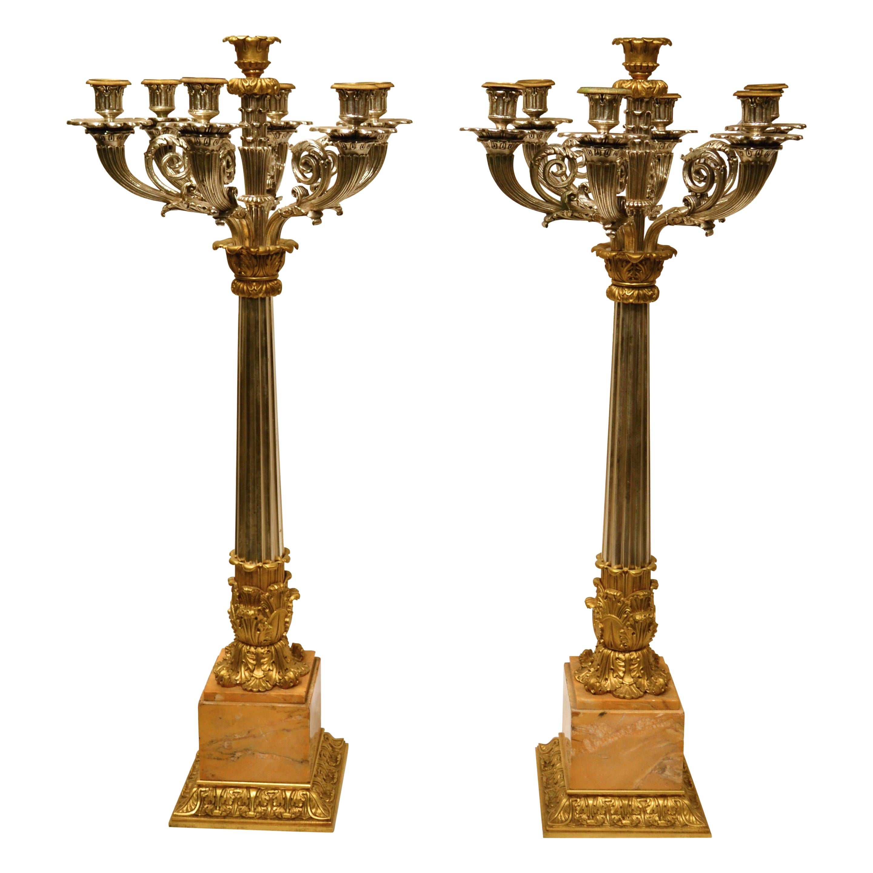 Paar versilberte und vergoldete Bronzekandelaber im Empire-Stil mit Marmorsockeln im Angebot