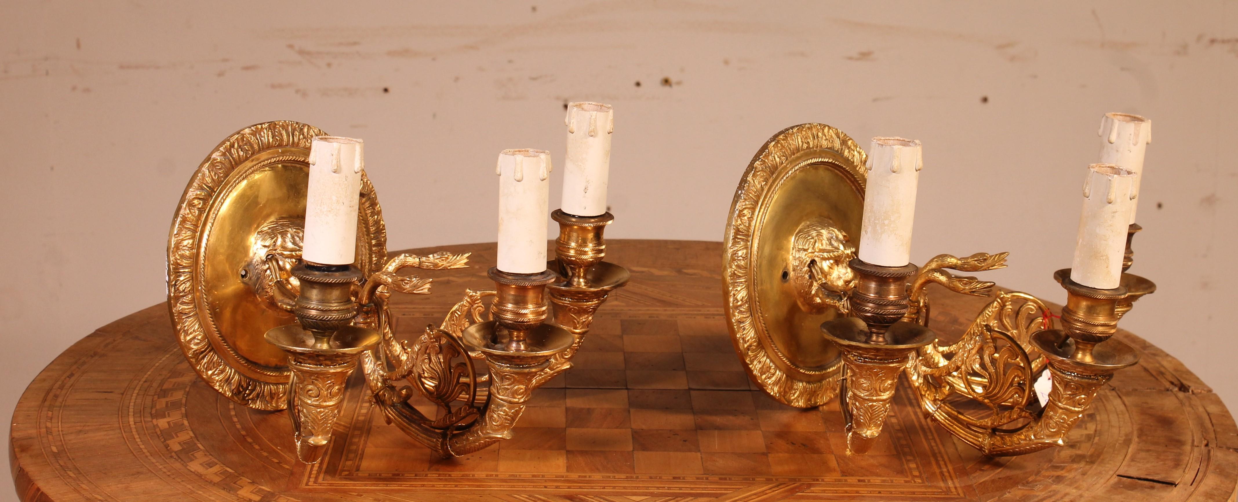 Very nice pair of chiseled bronze wall lights with very beautiful Empire style gilding from the beginning of the 20th century

Circular hook with lion mask holding in its mouth a flower crown from which the three arms of light escape.
We left the