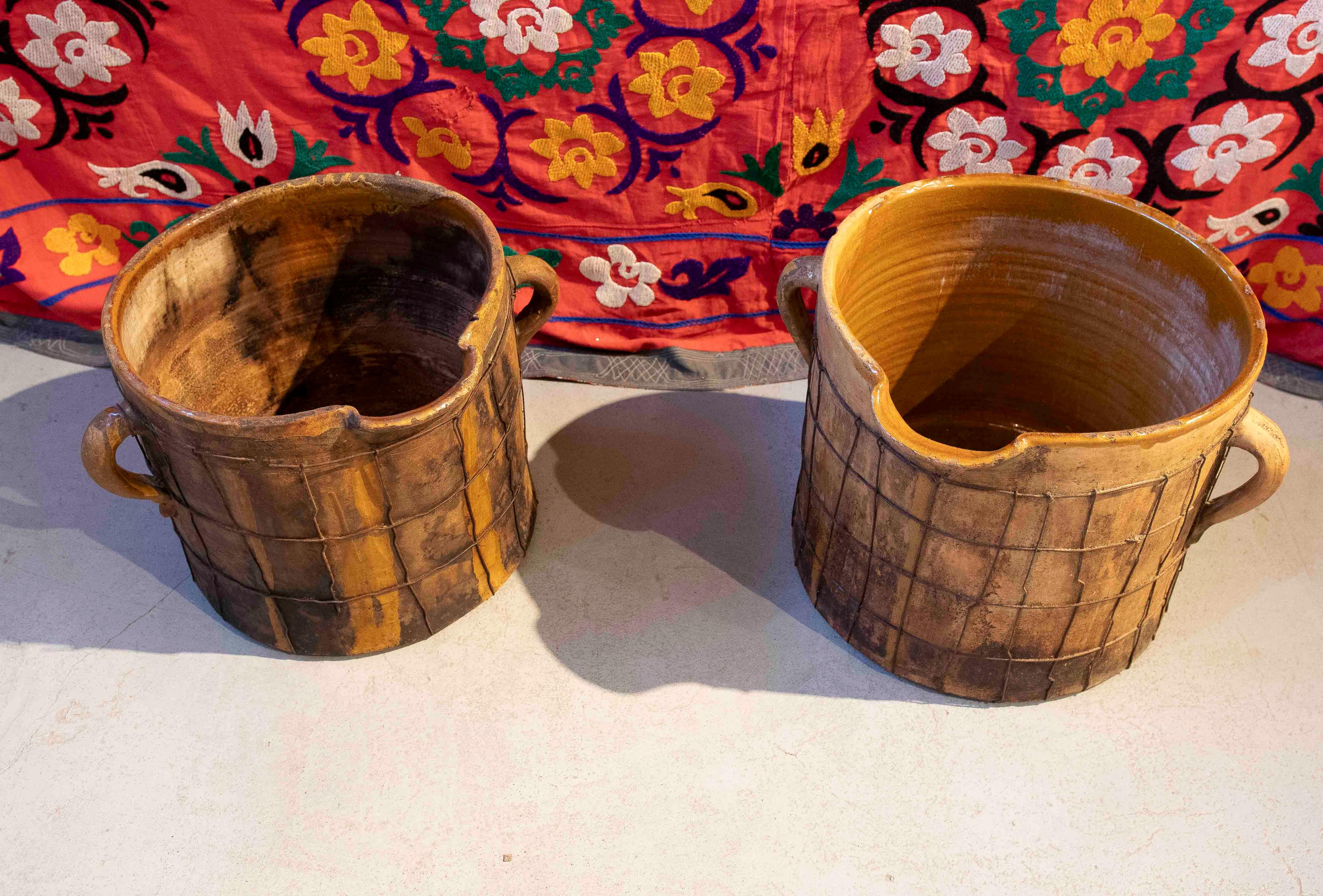 Spanish Pair of Enameled Ceramic Milk Churns with Handles & Iron Netting Covering Them For Sale