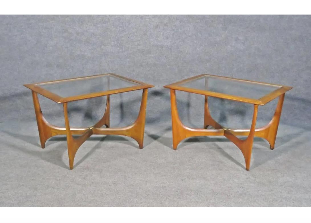 This pair of end tables features an elegant design combining walnut frames and glass tops. Artfully sculpted bases and a minimal square top make this sought-after design by Adrian Pearsall a true Mid-Century Modern gem. Please confirm item location
