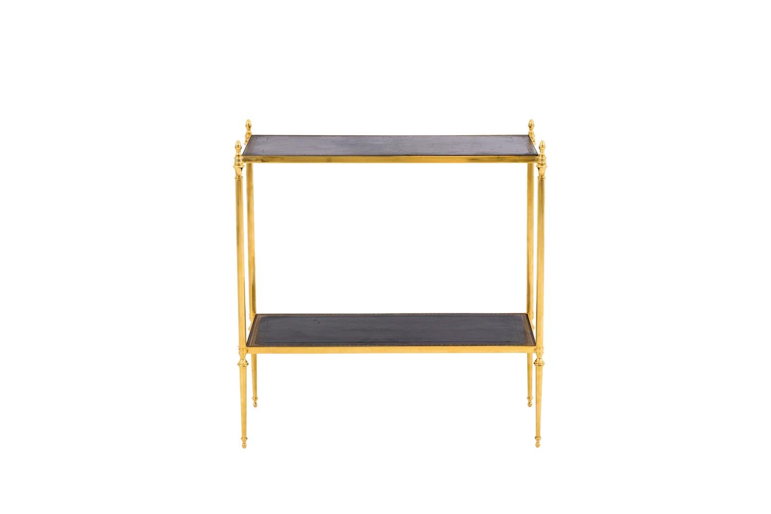 Maison Jansen, in the style of.
Pair of end tables in gilt brass standing on four fluted legs topped by acorns and finishing in tapered legs.
Two movable trays in black leather hit with small gilt irons by a scrolls frieze and framed by gilt brass