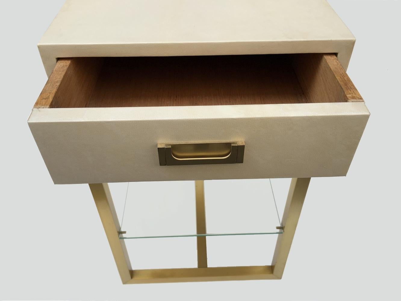 Pair of pedestal tables / end tables by Guy Lefevre for Maison Jansen, France 1970.
The base is in square patinated brass tube. the tray hiding a drawer is entirely wrapped in parchment.
A glass shelf rests on brass tabs at a third of the height