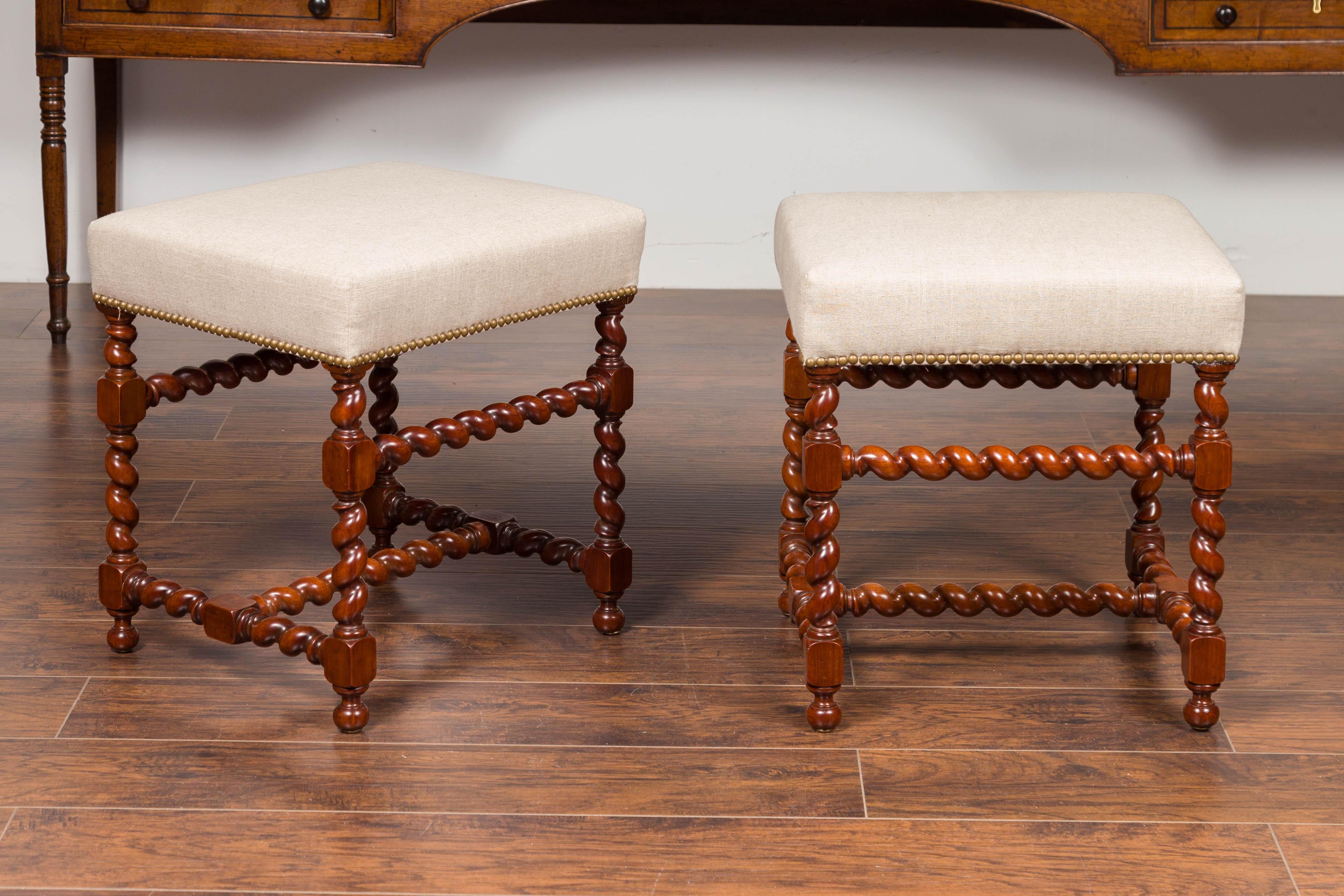 A pair of English walnut stools from the mid-19th century, with barley twist base and new upholstery. Born in England during the third quarter of the 19th century, each of this pair of walnut stools features a rectangular seat newly recovered with a