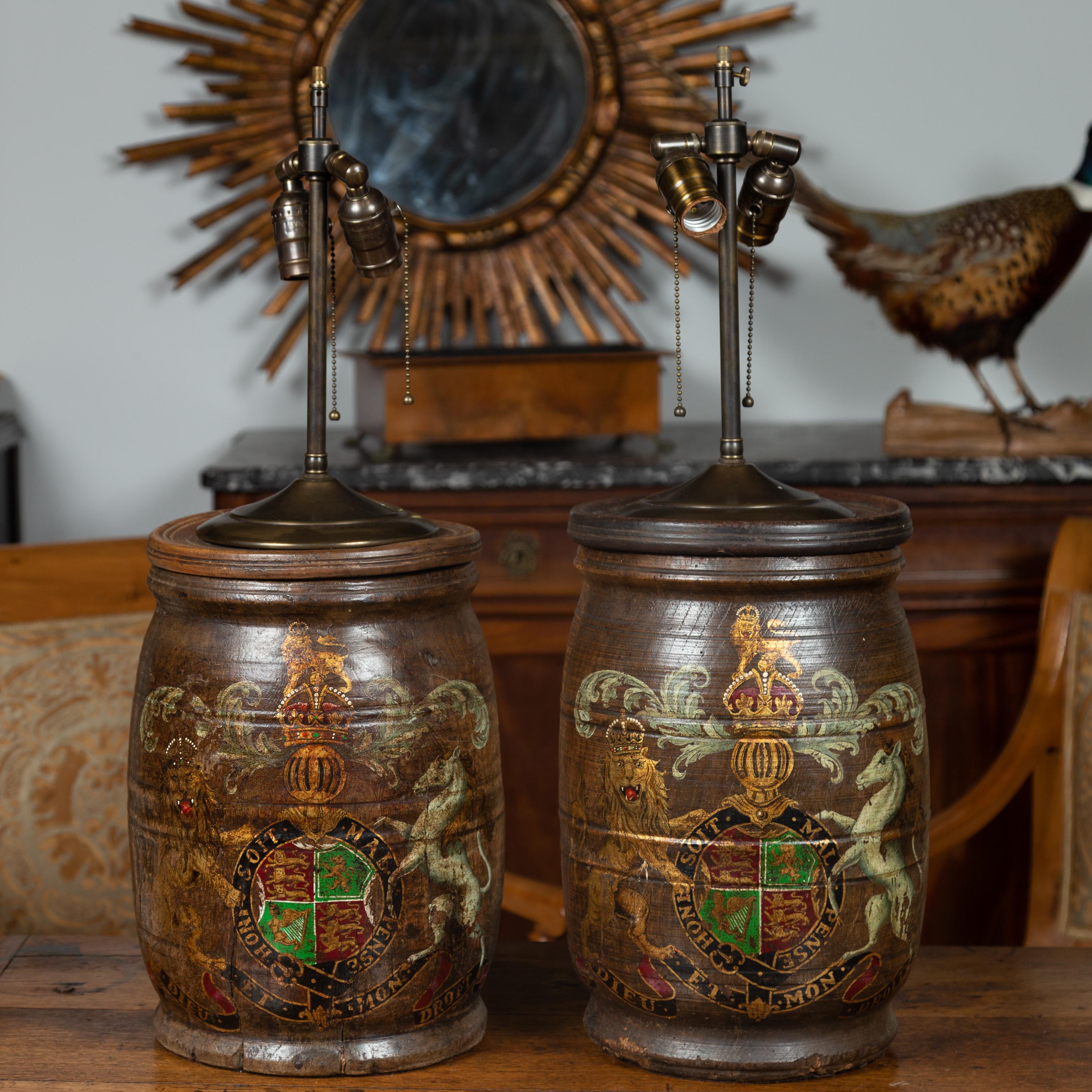 A pair of English wooden barrels from the late 19th century with the United Kingdom’s royal coat of arms, made into two-light table lamps. Born in England during the last quarter of the 19th century, this pair of English wooden barrels has been