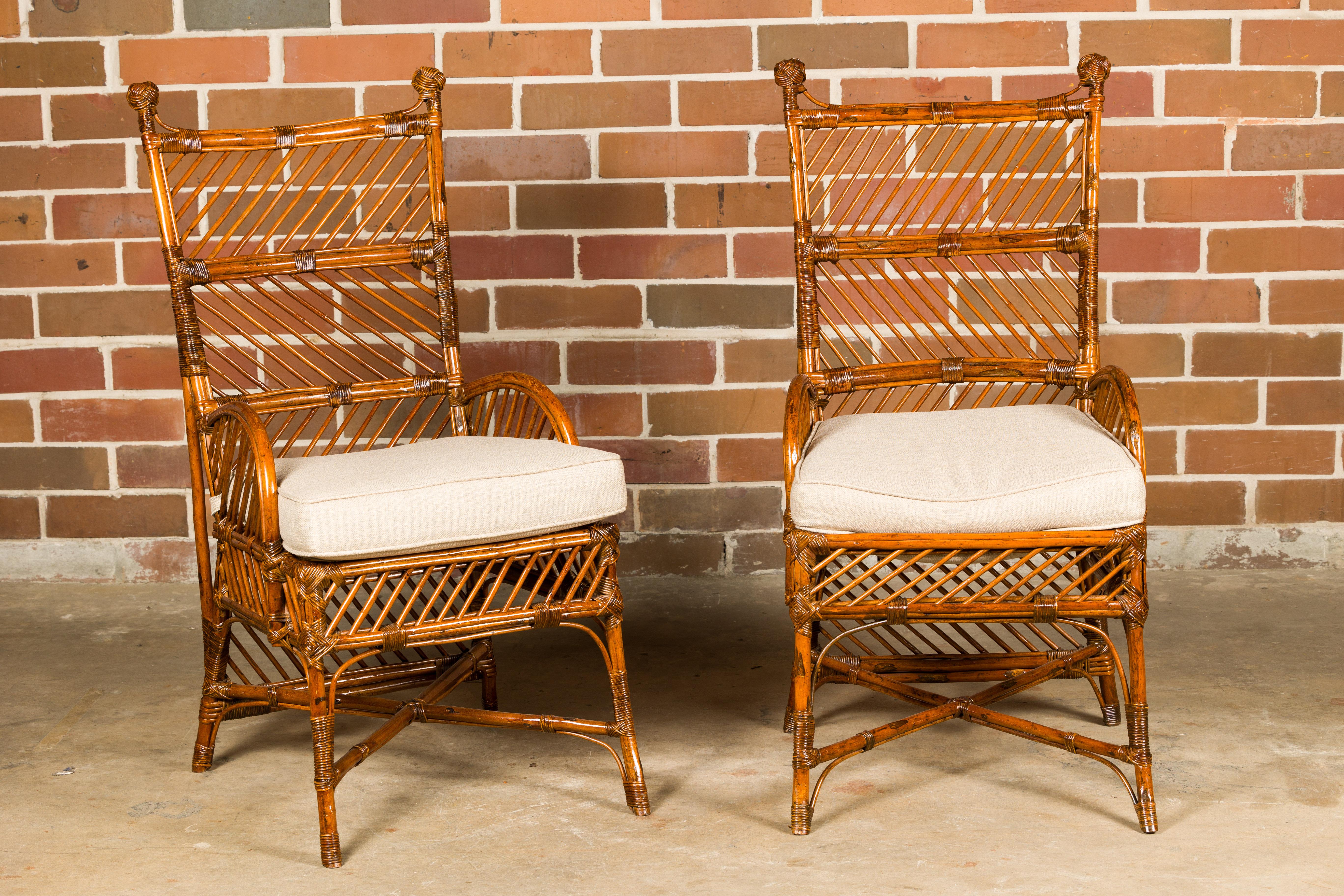 A pair of English bamboo and rattan chairs from circa 1890-1920 with custom cushions. These exquisite English bamboo and rattan chairs, hailing from the late 19th to early 20th century, are a delightful fusion of vintage charm and tropical allure.
