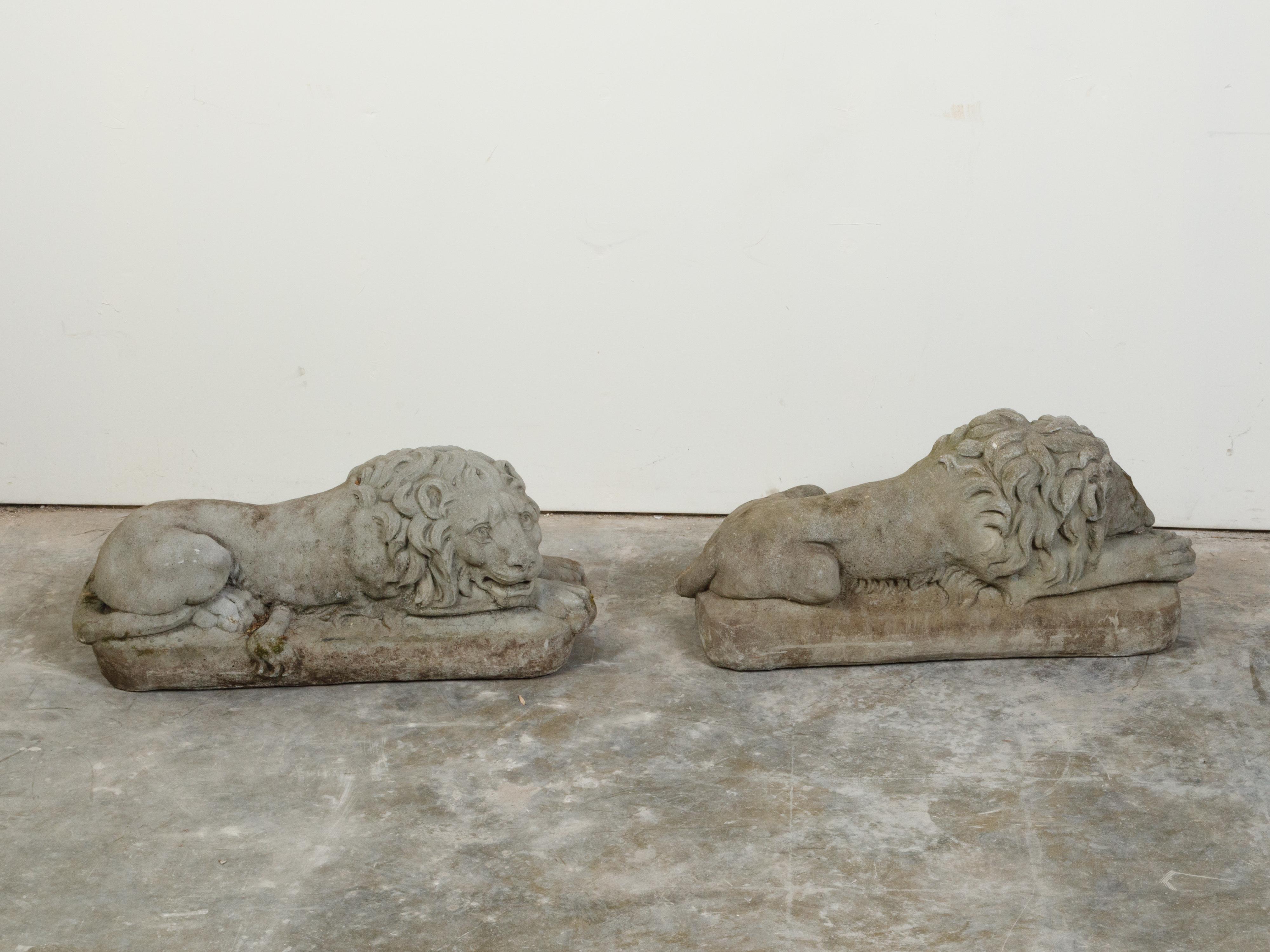 Pair of English 1920s Cast Stone Reclining Lion Sculptures on Conforming Bases In Good Condition For Sale In Atlanta, GA