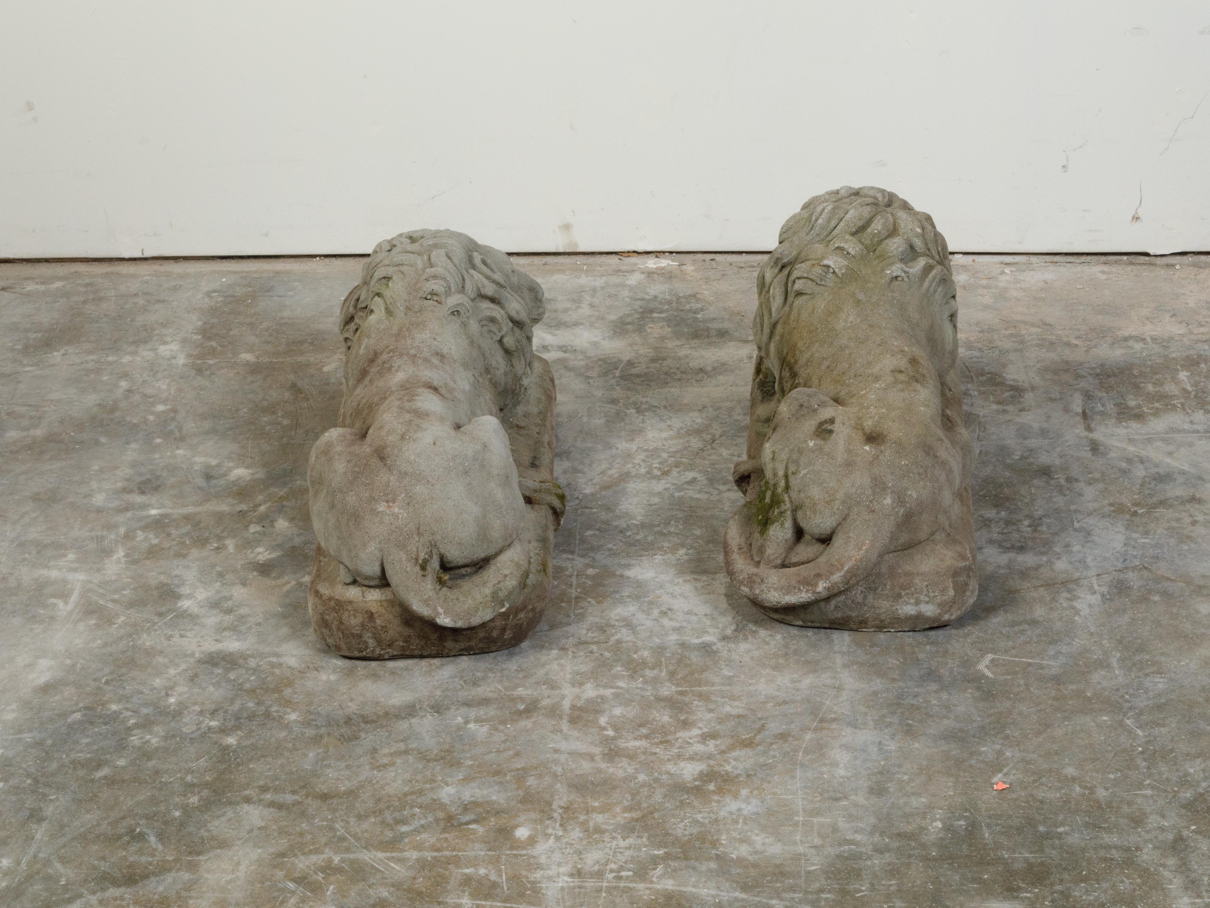 Pair of English 1920s Cast Stone Reclining Lion Sculptures on Conforming Bases For Sale 1