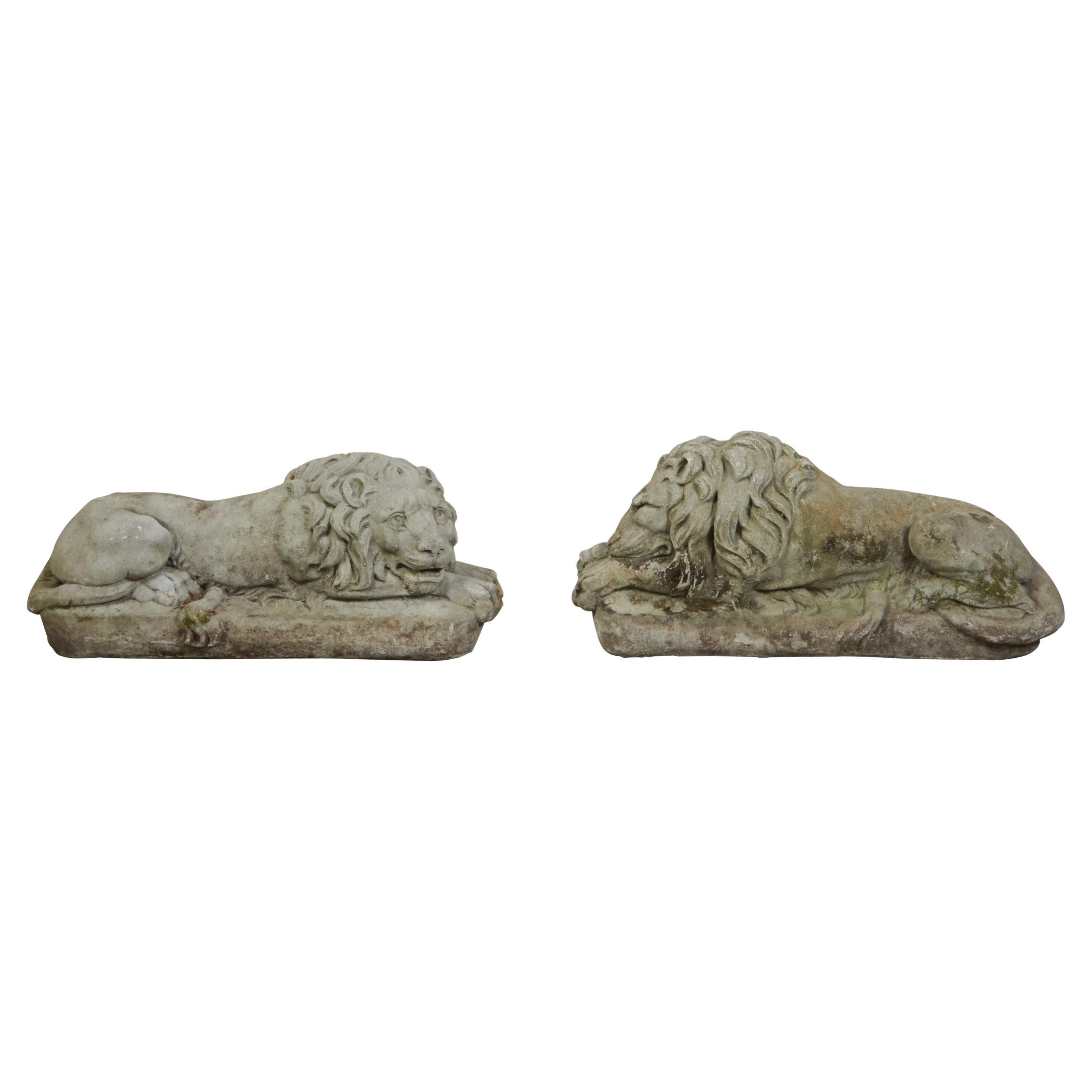 Pair of English 1920s Cast Stone Reclining Lion Sculptures on Conforming Bases For Sale