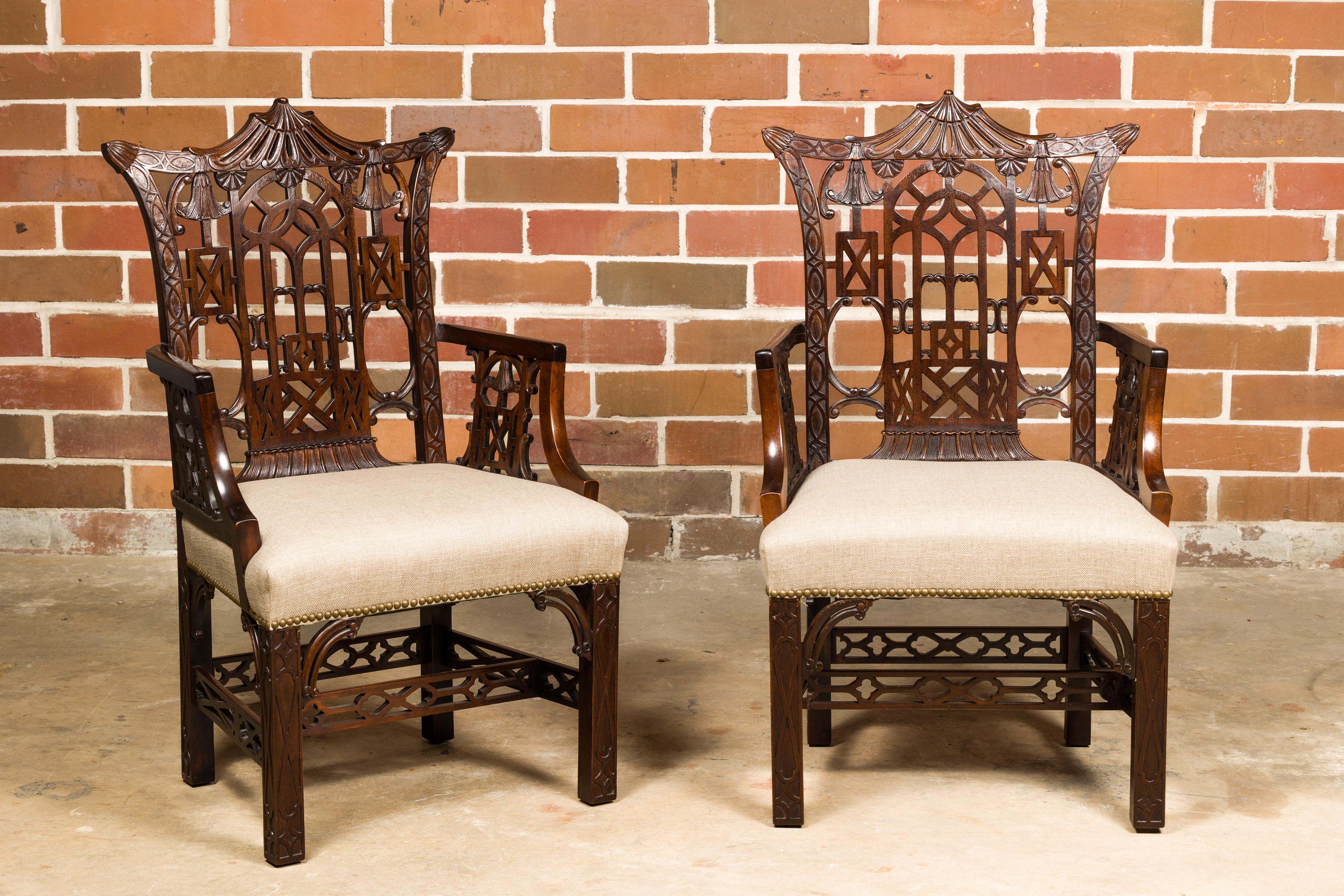 A pair of English Chippendale armchairs from the 19th century with richly carved décor and new custom linen upholstery. These English Chippendale armchairs, dating back to the 19th century, are a splendid testament to timeless elegance and