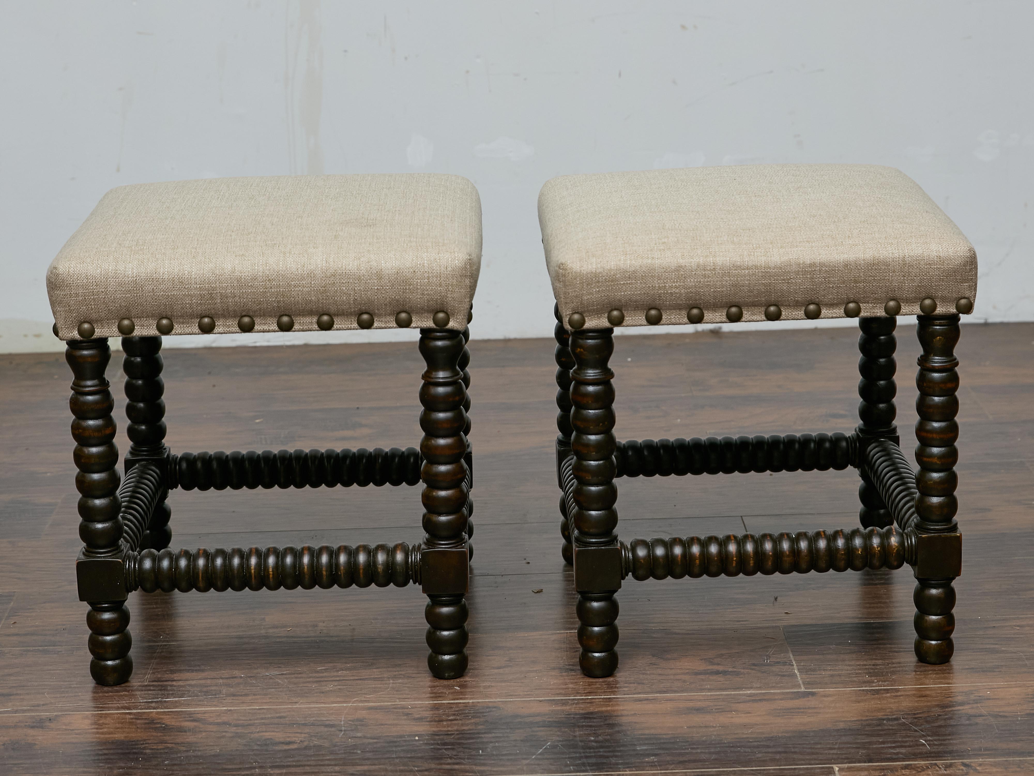 This pair of 19th-century English stools combines classic craftsmanship with updated upholstery, offering both character and versatility. The ebonized wood frames highlight the sculptural beauty of bobbin-turned legs, a design element that adds a